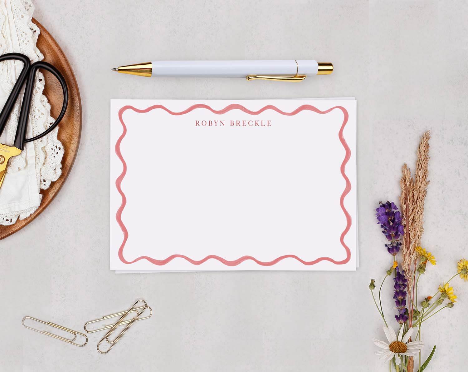 Pink Wavy Personalised Note Cards on a desk with a pen and stationery, featuring a modern wave design.
