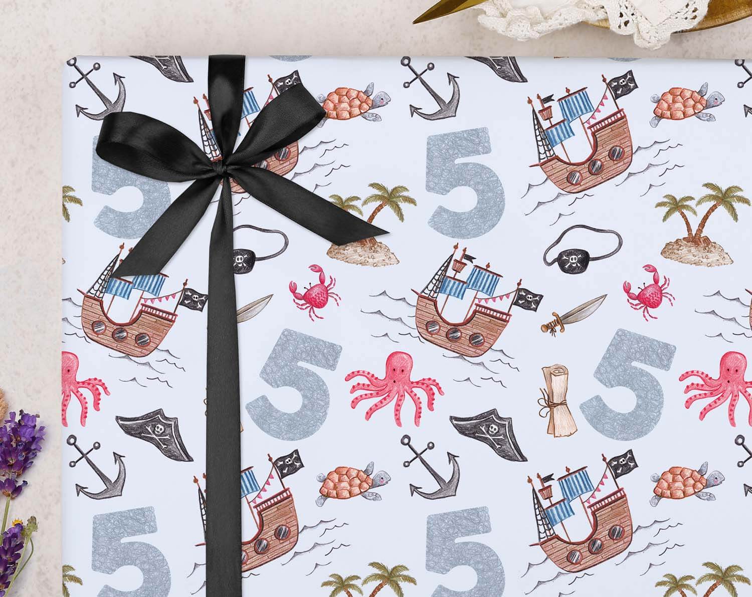 Pirate 5th Birthday Wrapping Paper featuring vibrant pirate designs and a black ribbon for a festive look.