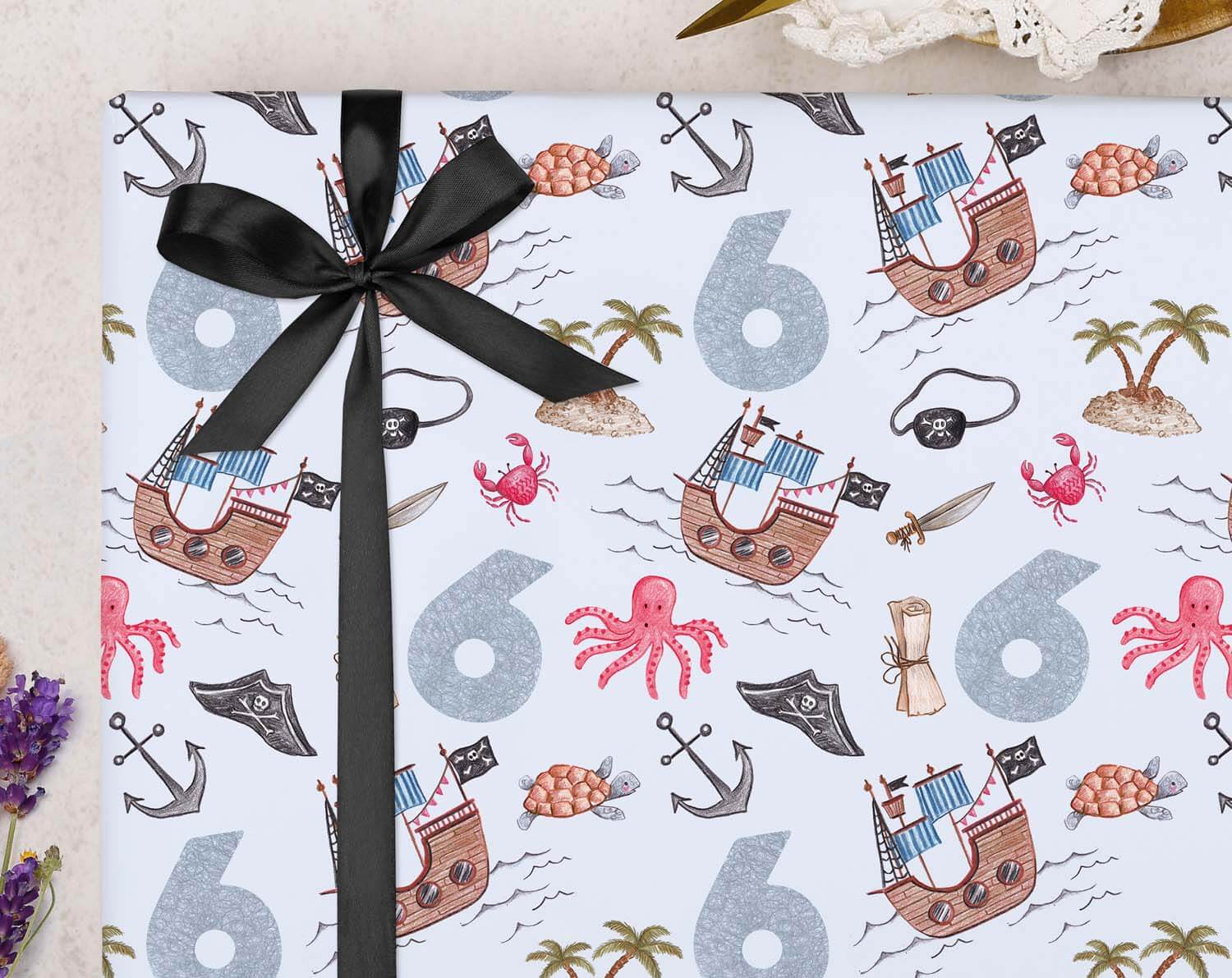 Pirate 6th Birthday Wrapping Paper featuring bold pirate designs and the number 6 with a black ribbon.