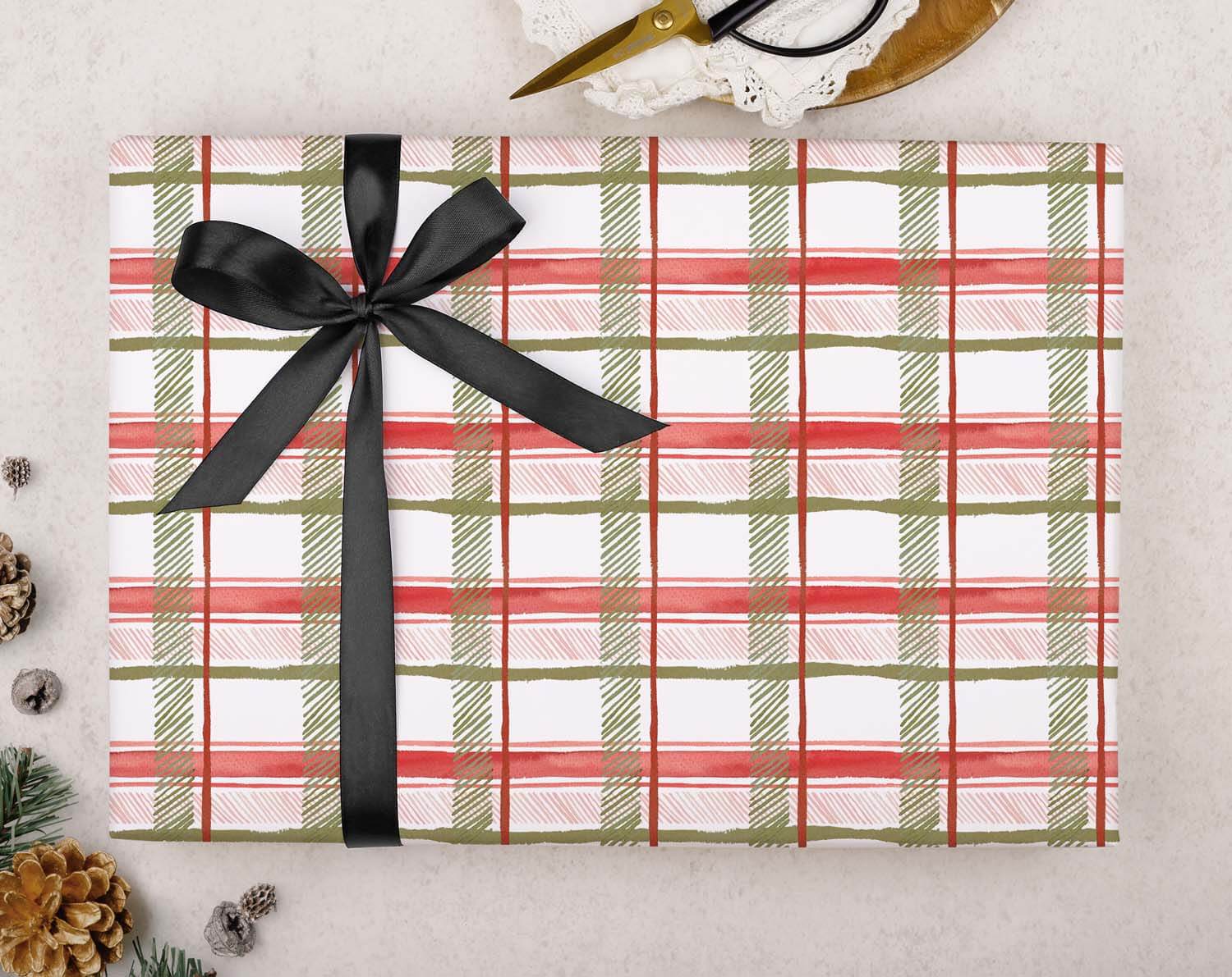 Red Tartan Christmas Wrapping Paper beautifully wrapped with a black ribbon and scissors on a rustic background.