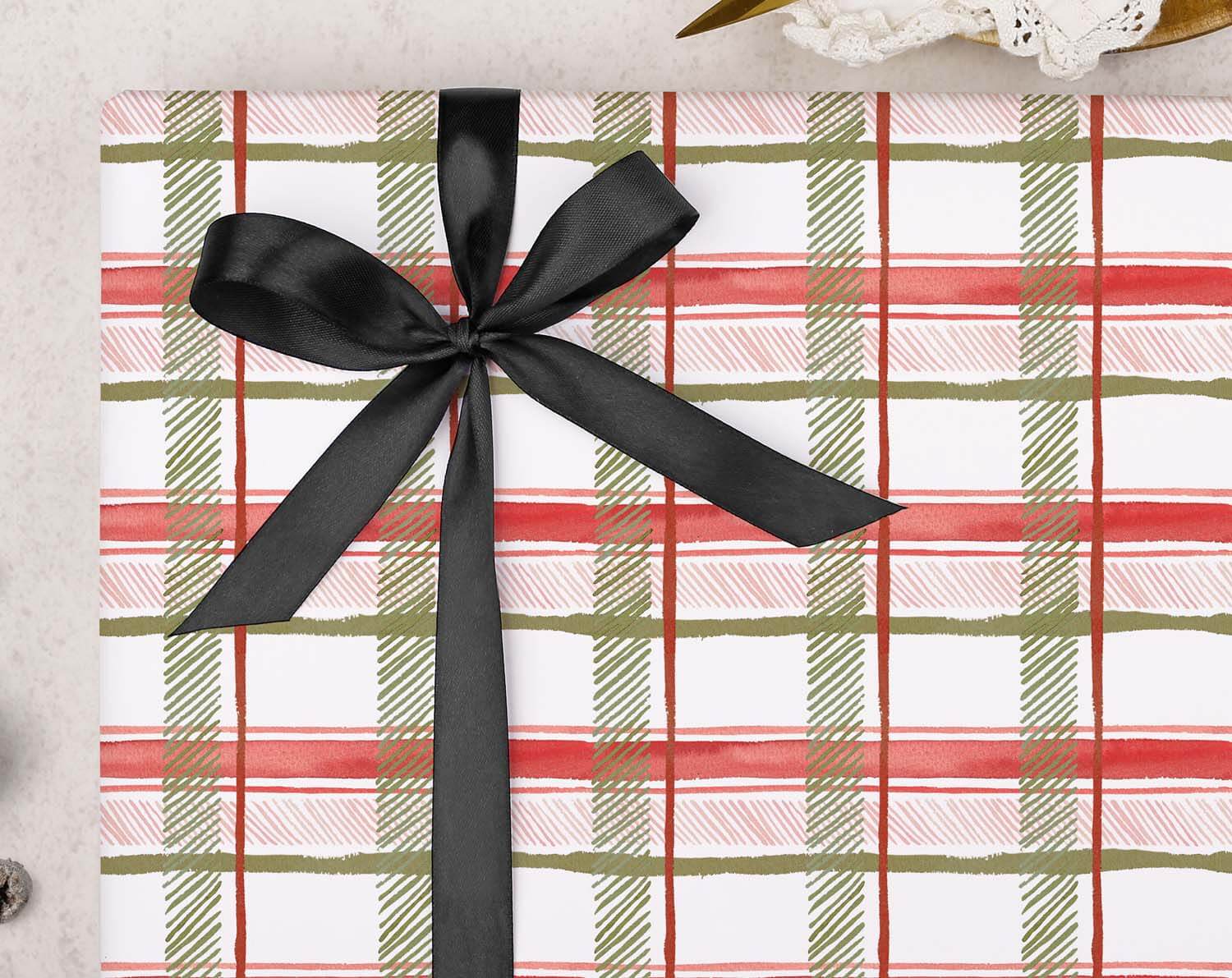 Red Tartan Christmas Wrapping Paper with black ribbon bow on top, perfect for festive gift wrapping.