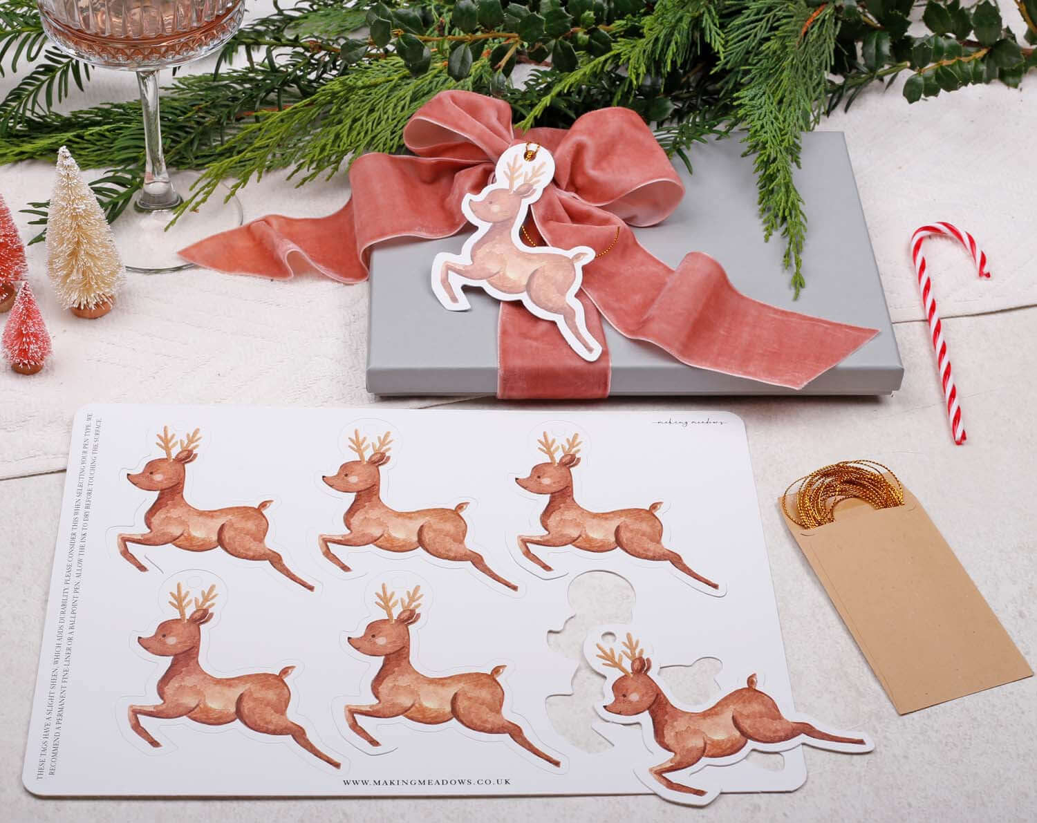 Reindeer Christmas Gift Tags - 12 Pack displayed on a gift with festive decorations and twine.