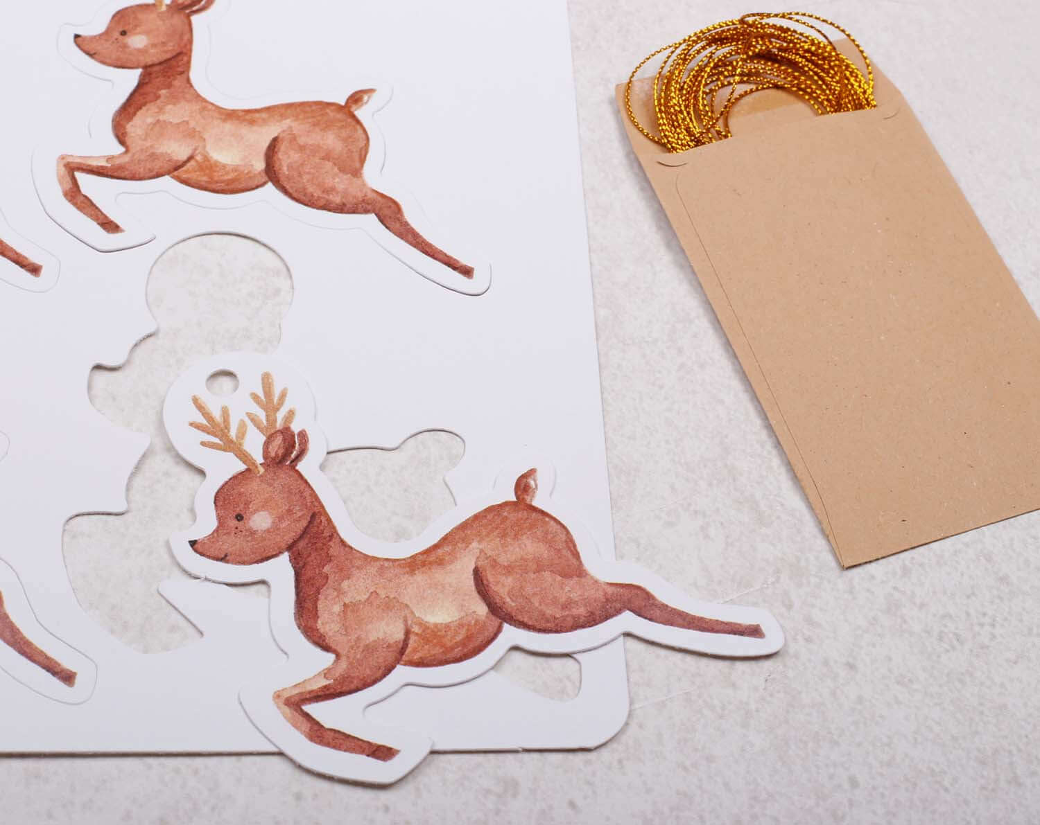 Reindeer Christmas Gift Tags featuring charming reindeer illustrations and gold twine for festive gift wrapping.