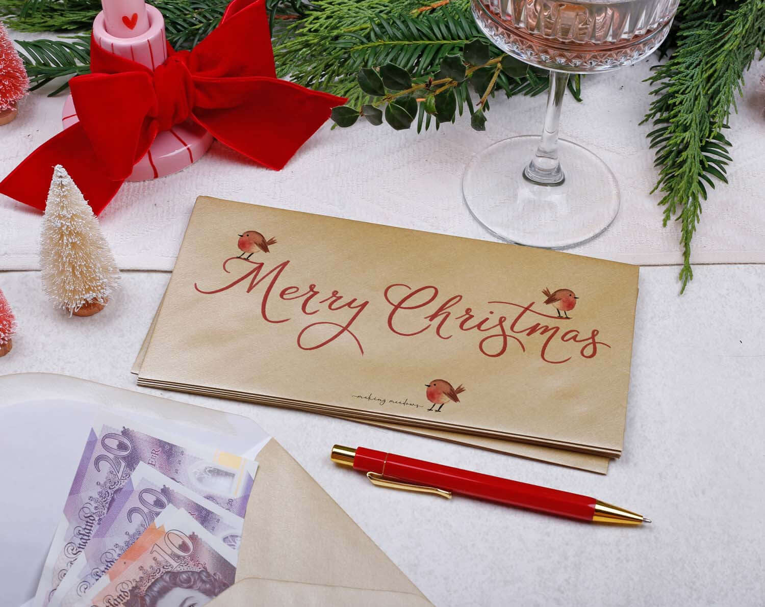 Robin Christmas Money Envelopes featuring a luxurious gold finish and festive robin illustration on a holiday table.