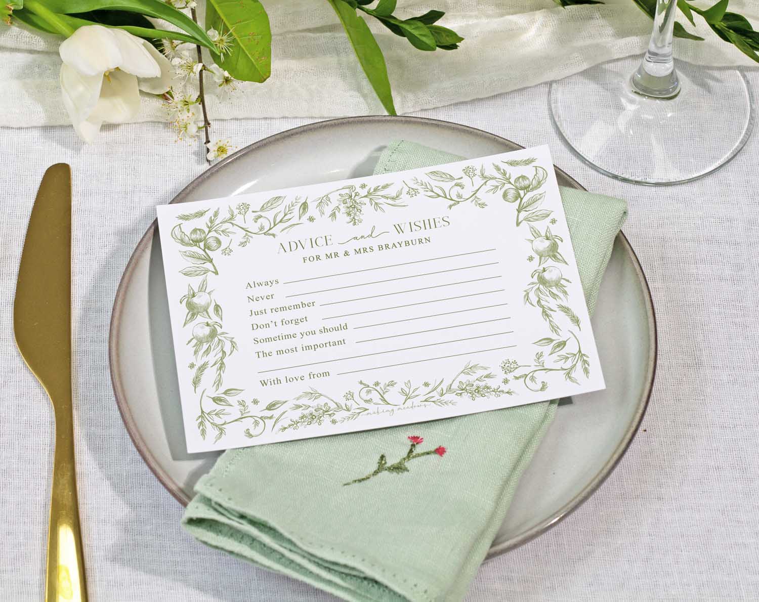 Sage Garden Wedding Advice Cards on a plate with a green napkin and floral decoration.