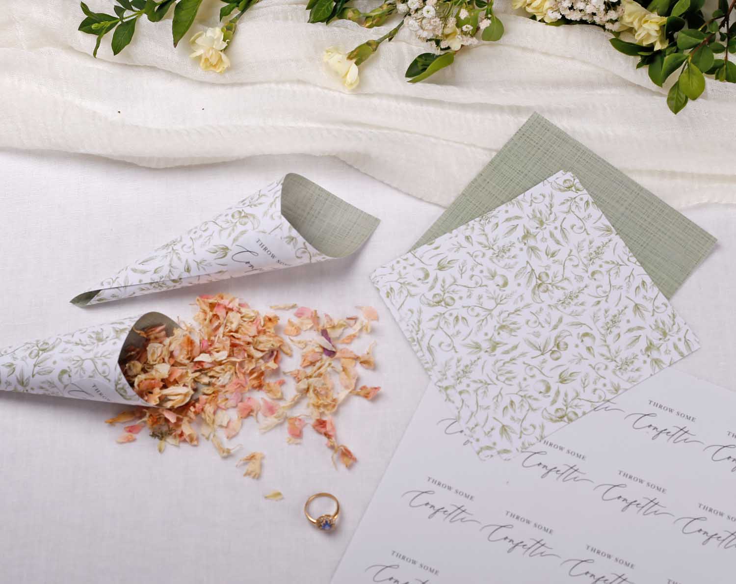 Sage Garden Wedding Confetti Cones displayed with dried flower petals and stationery on a table setting.