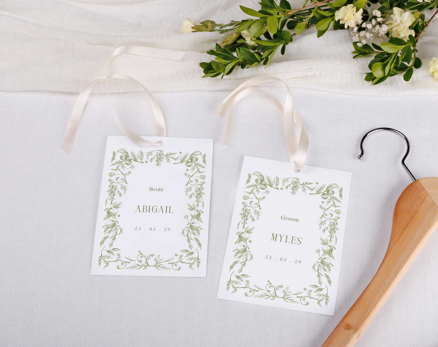 Sage Garden Wedding Hanger Tags for bridal party feature green floral design with names Abigail and Myles.