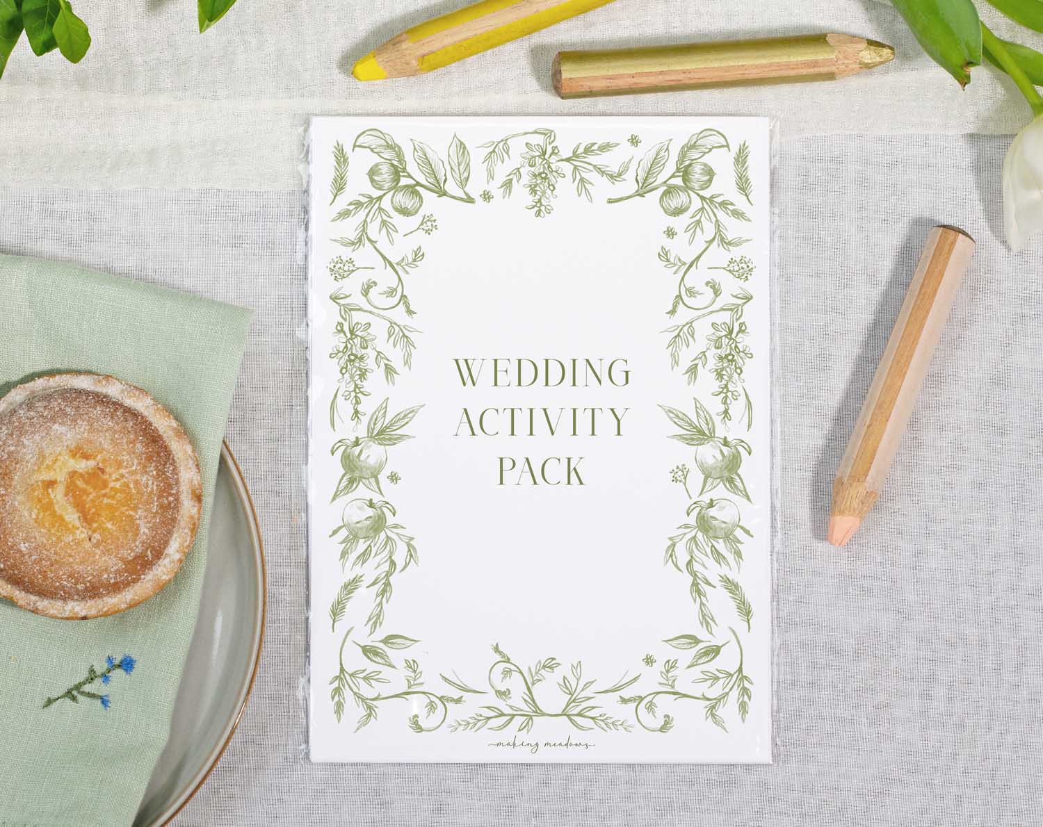 Sage Garden Wedding Kids Activity Pack with decorative floral border on wedding table.