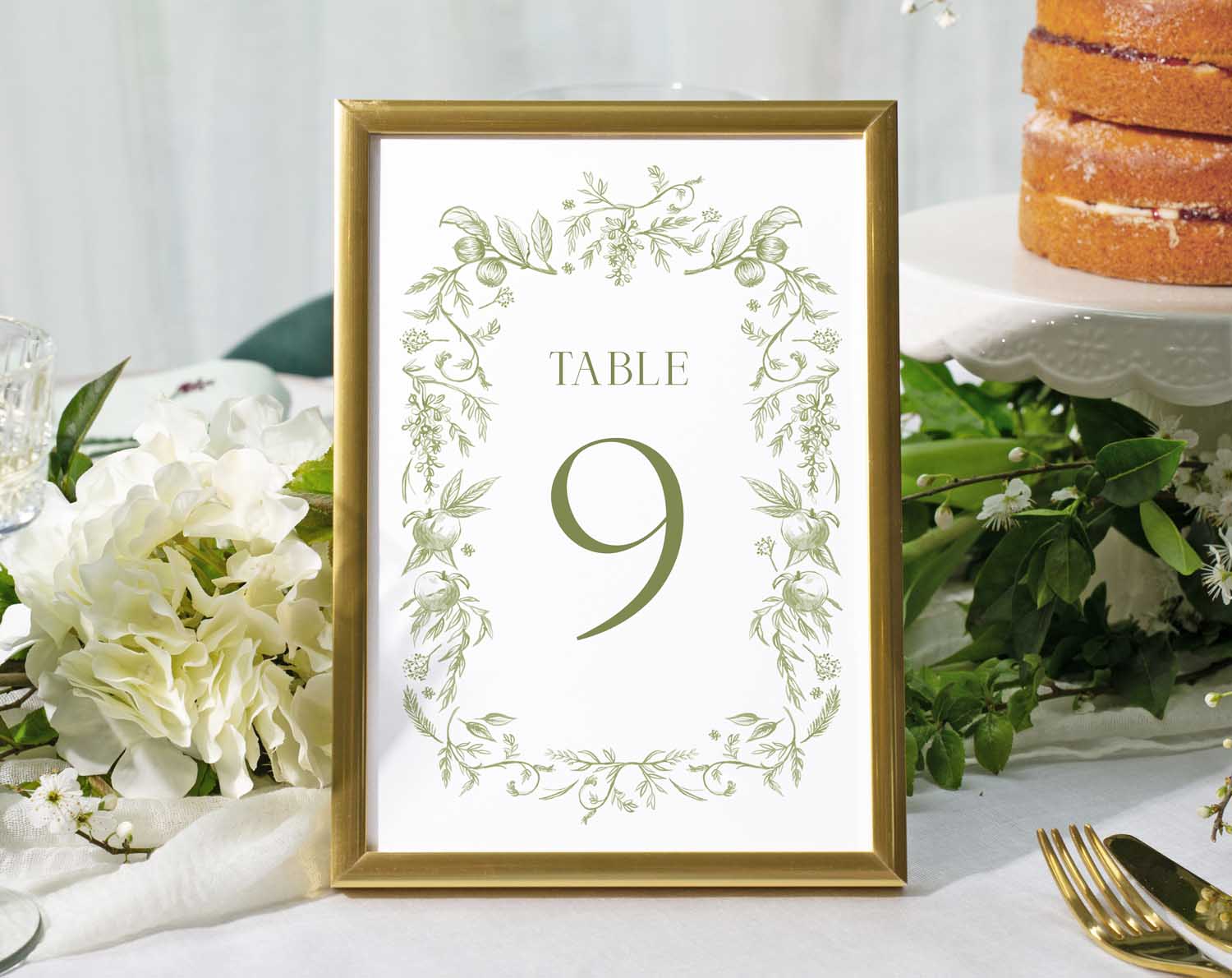 Sage Garden Wedding Table Numbers with delicate botanicals and Table 9 design in a gold frame on a reception table.