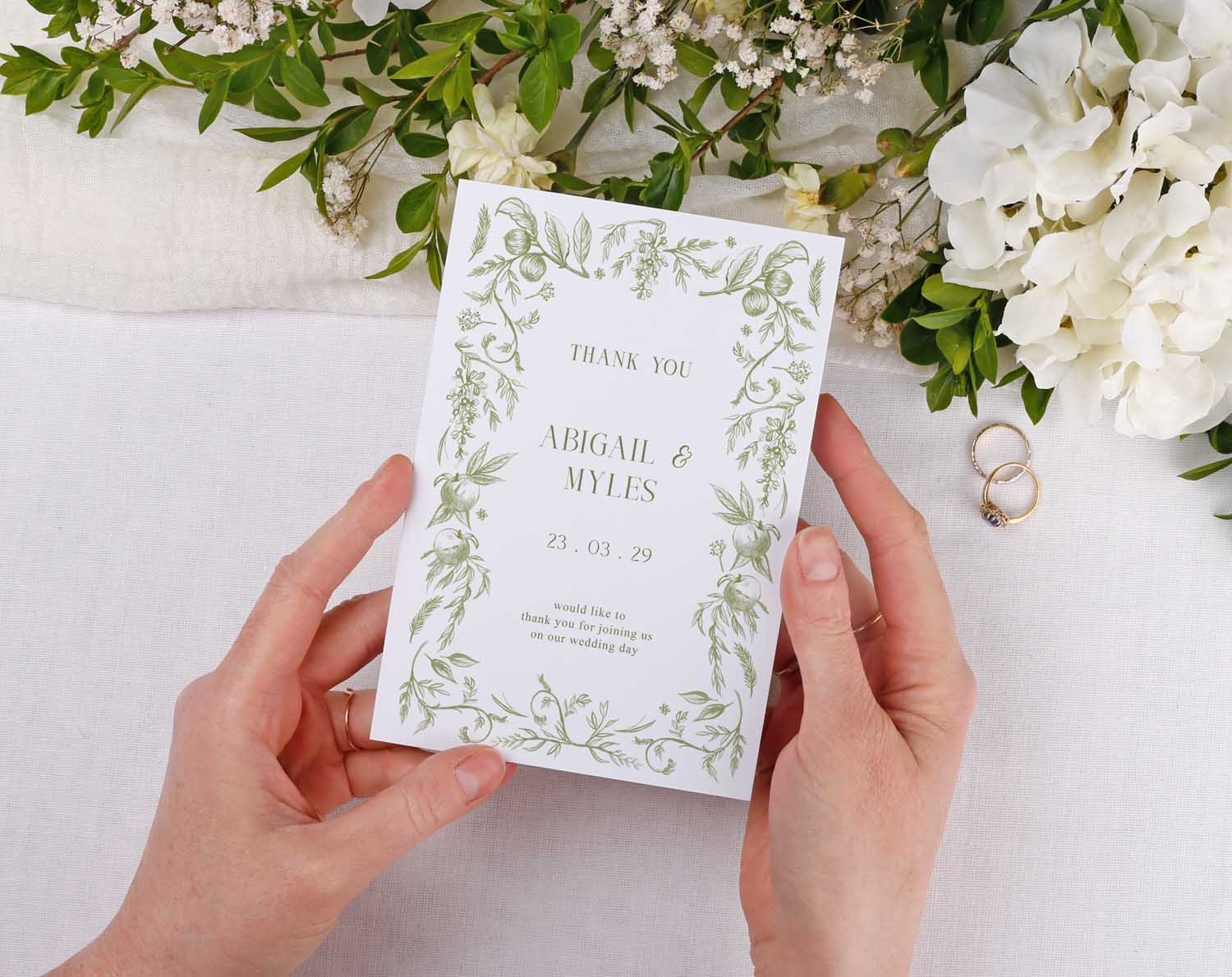 Sage Garden Wedding Thank You Cards held by hands with floral design, expressing gratitude after a wedding.