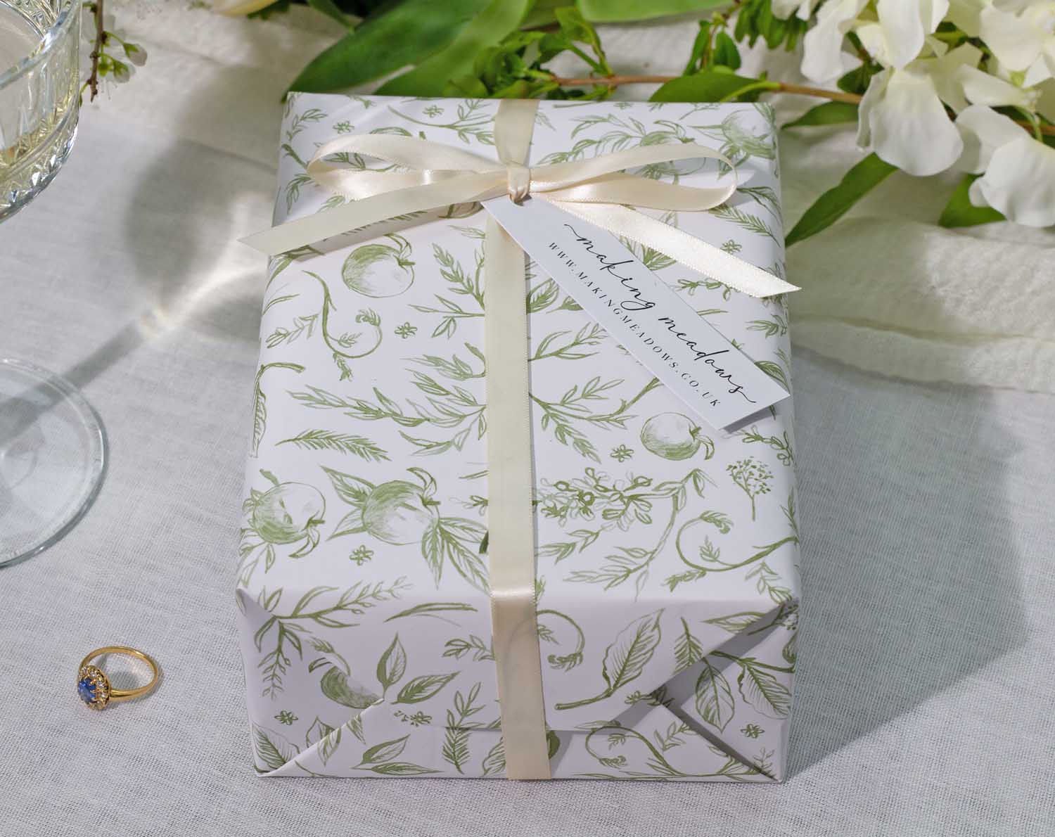 Sage Garden Wedding Wrapping Paper elegantly wrapped gift with floral design and ribbon, perfect for special occasions.
