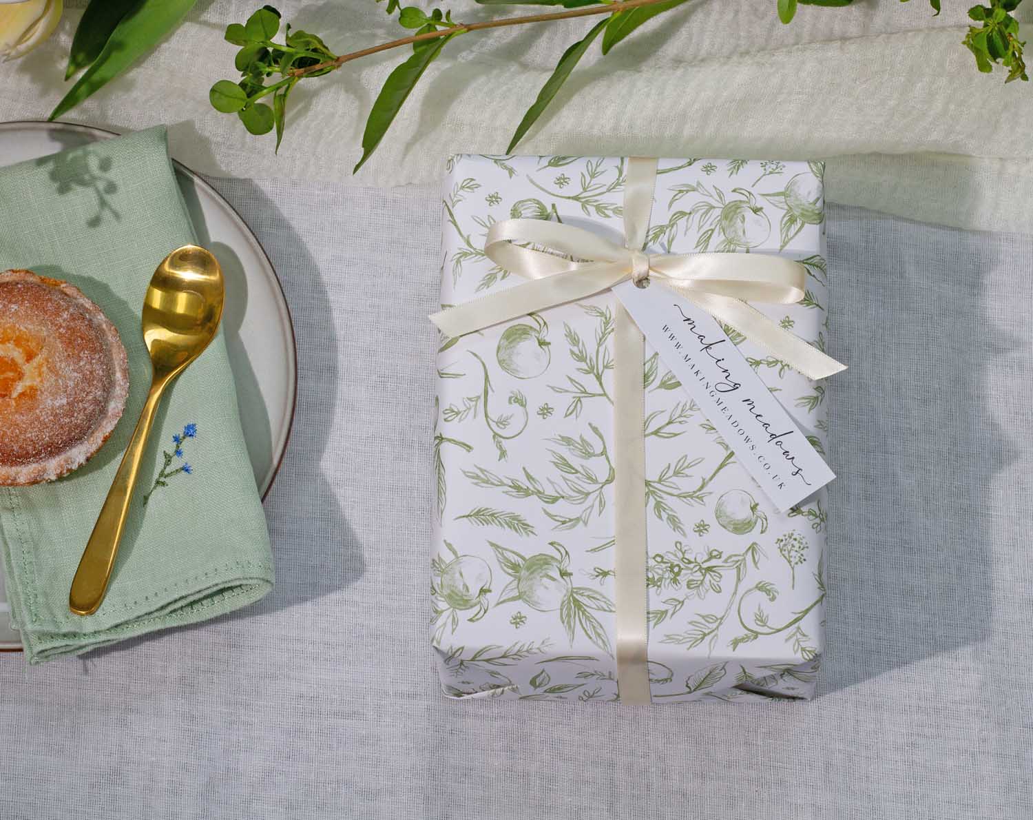 Sage Garden Wedding Wrapping Paper beautifully wrapped gift with a ribbon on a table setting.