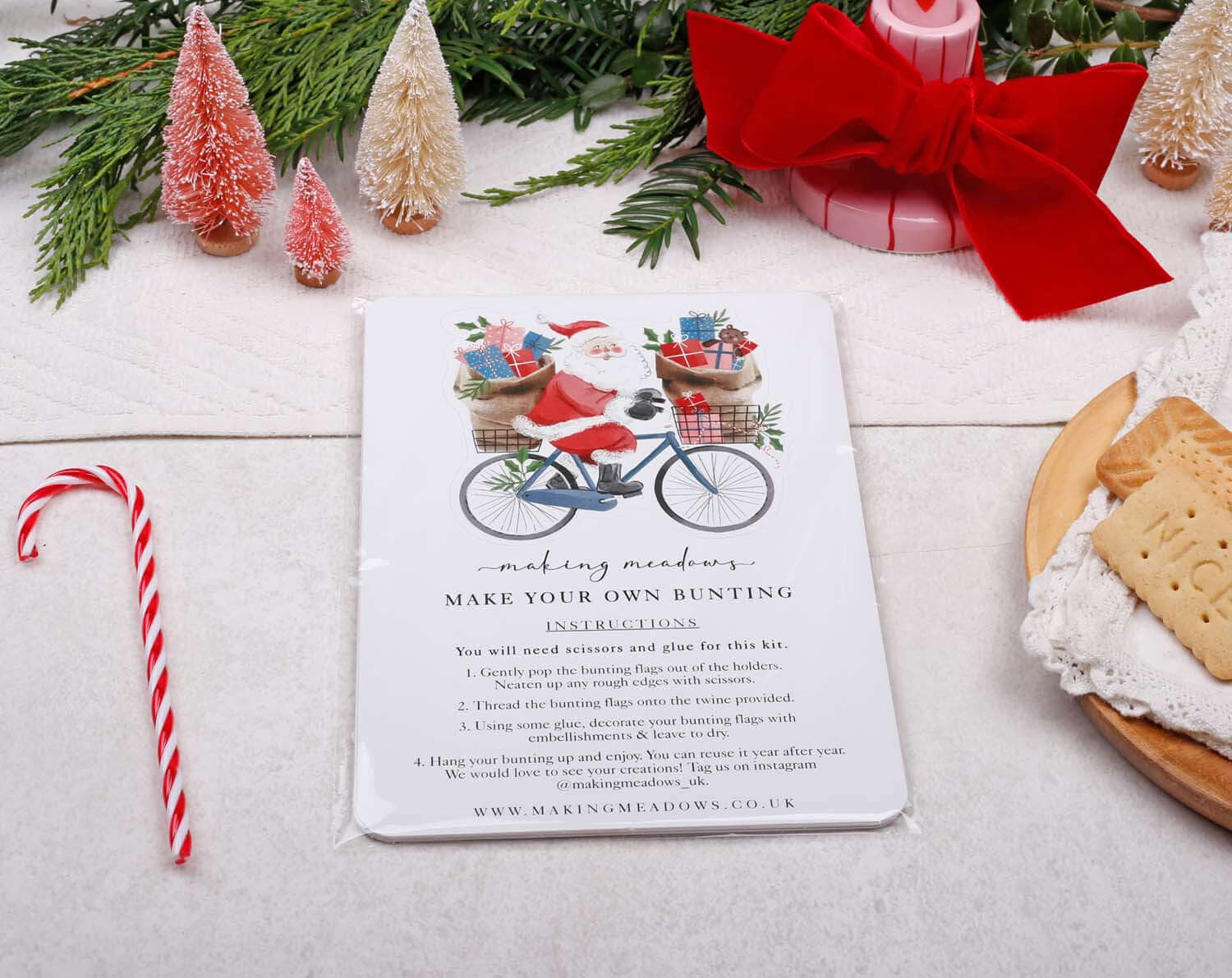 Santa Christmas Bunting instruction kit with Santa on a bicycle among festive decorations.