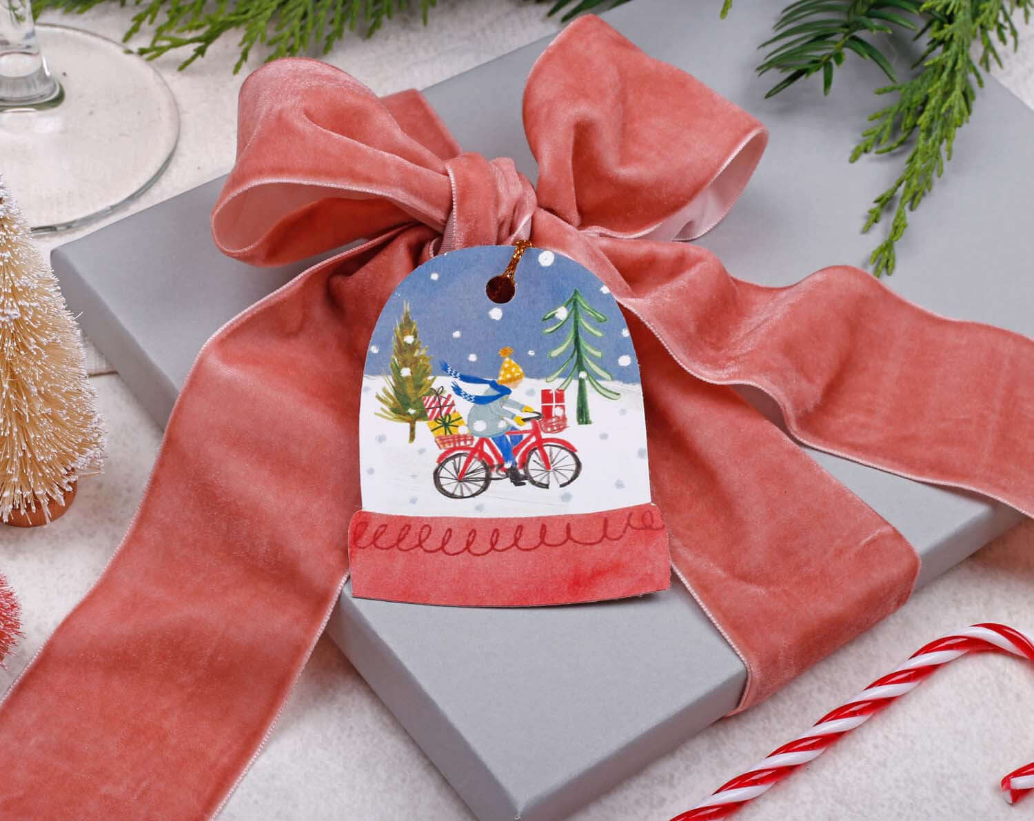 Snow Globe Christmas Gift Tags - 16 Pack on a gift wrapped with pink velvet ribbon, festive holiday decor.