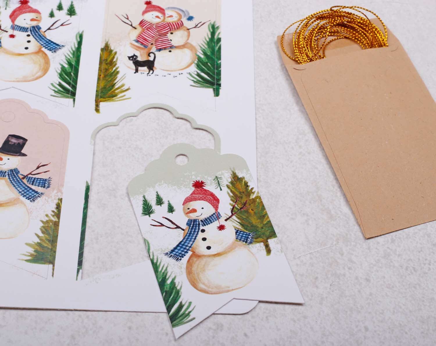 Snowman Christmas Gift Tags featuring cheerful snowman illustrations with gold twine for festive wrapping.