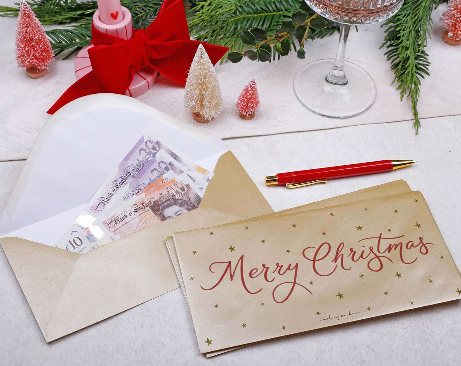 Star Christmas Money Envelopes with cash, festive decorations, and a pen for holiday gifting magic.