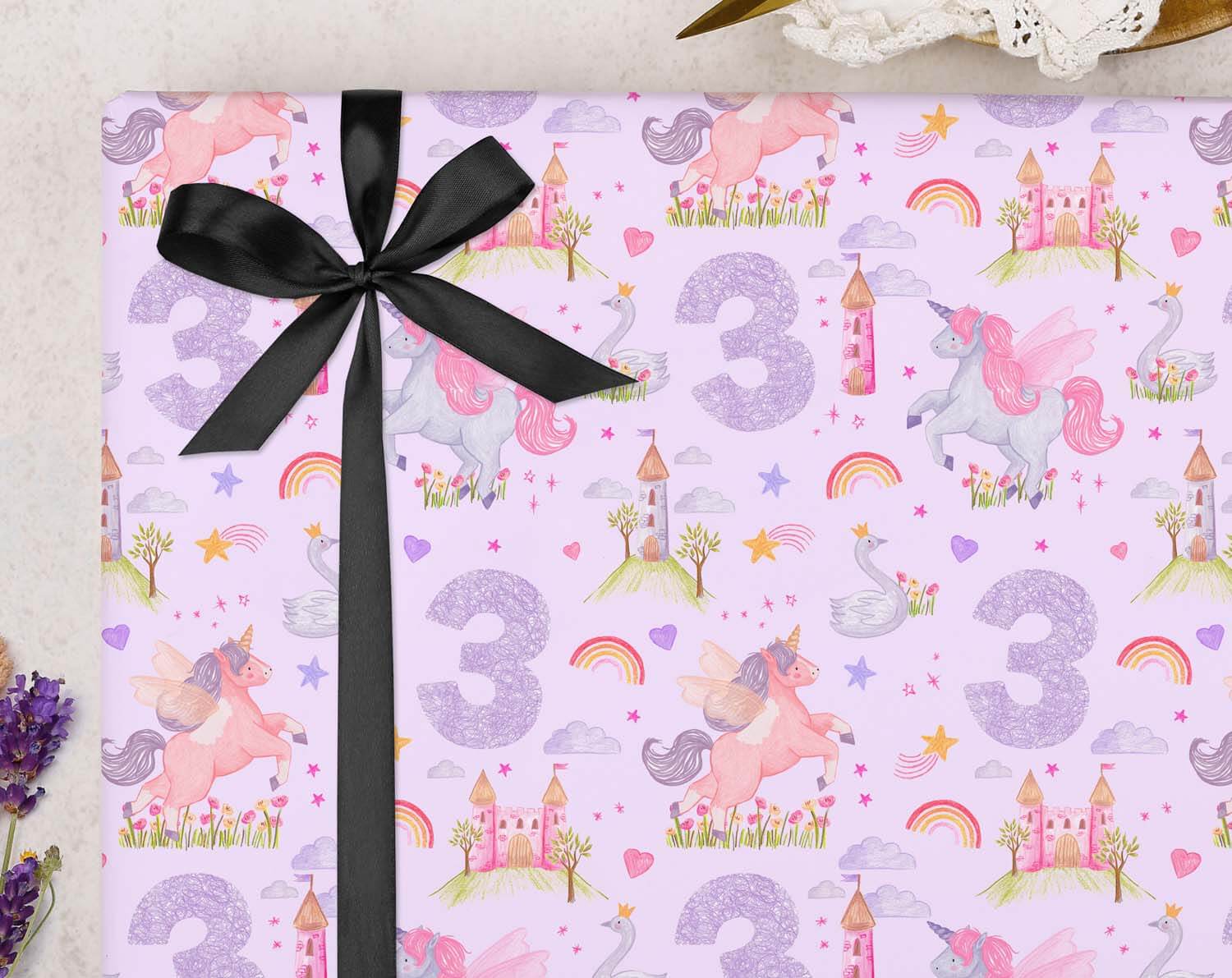 Unicorn 3rd Birthday Wrapping Paper with a black ribbon, featuring unicorns, castles, and the number 3 design.