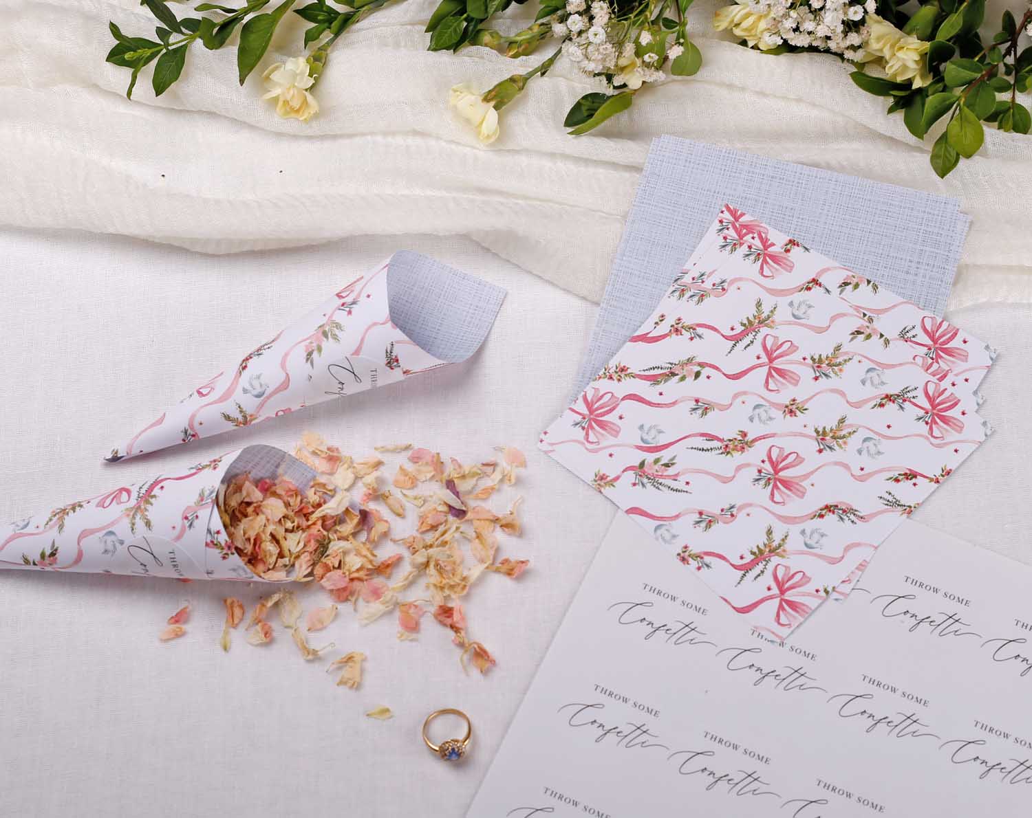 Vintage Wedding Confetti Cones with floral design and dried petals on a white tablecloth, perfect for wedding ceremonies.
