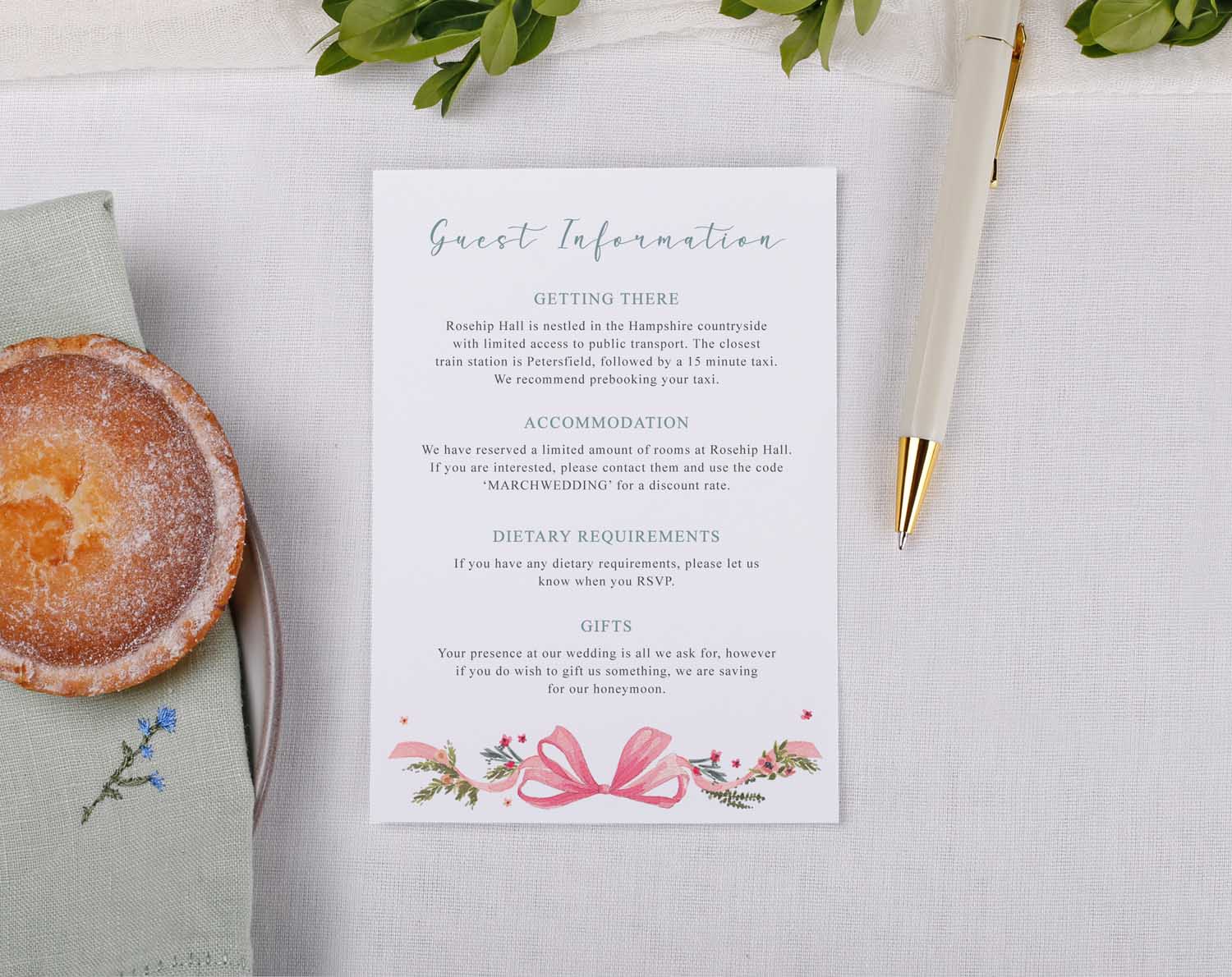 Vintage Wedding Information Cards displayed on a table with a pen, pastry, and a napkin, providing wedding details for guests.