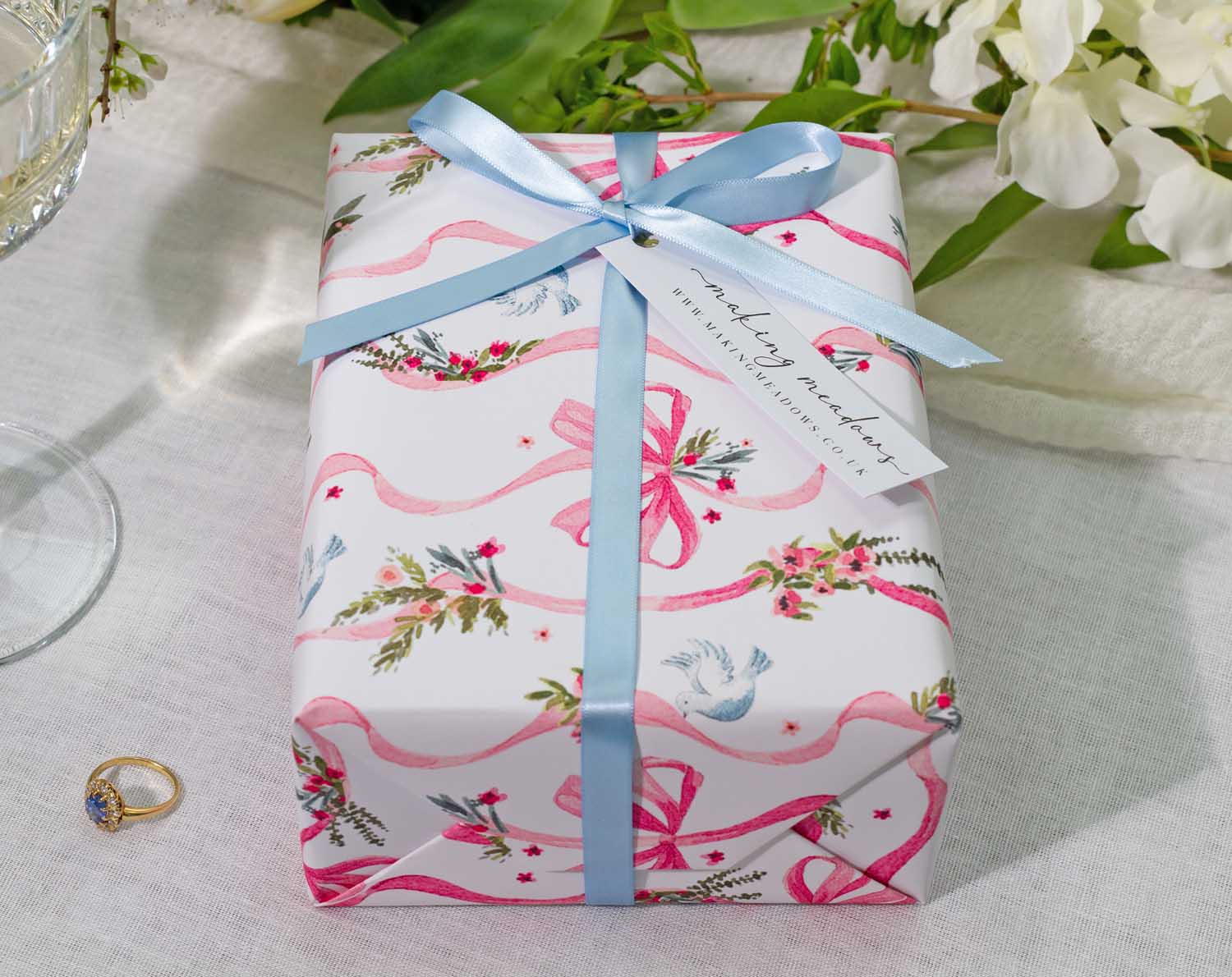 Vintage Wedding Wrapping Paper beautifully wraps a gift, adorned with floral designs and ribbons, perfect for weddings and engagements.