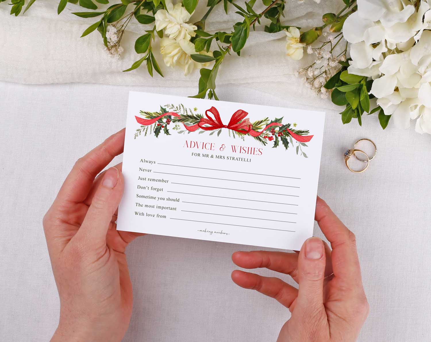 A person holding Winter Wedding Advice Cards with floral design, a keepsake for guests to share advice and wishes.
