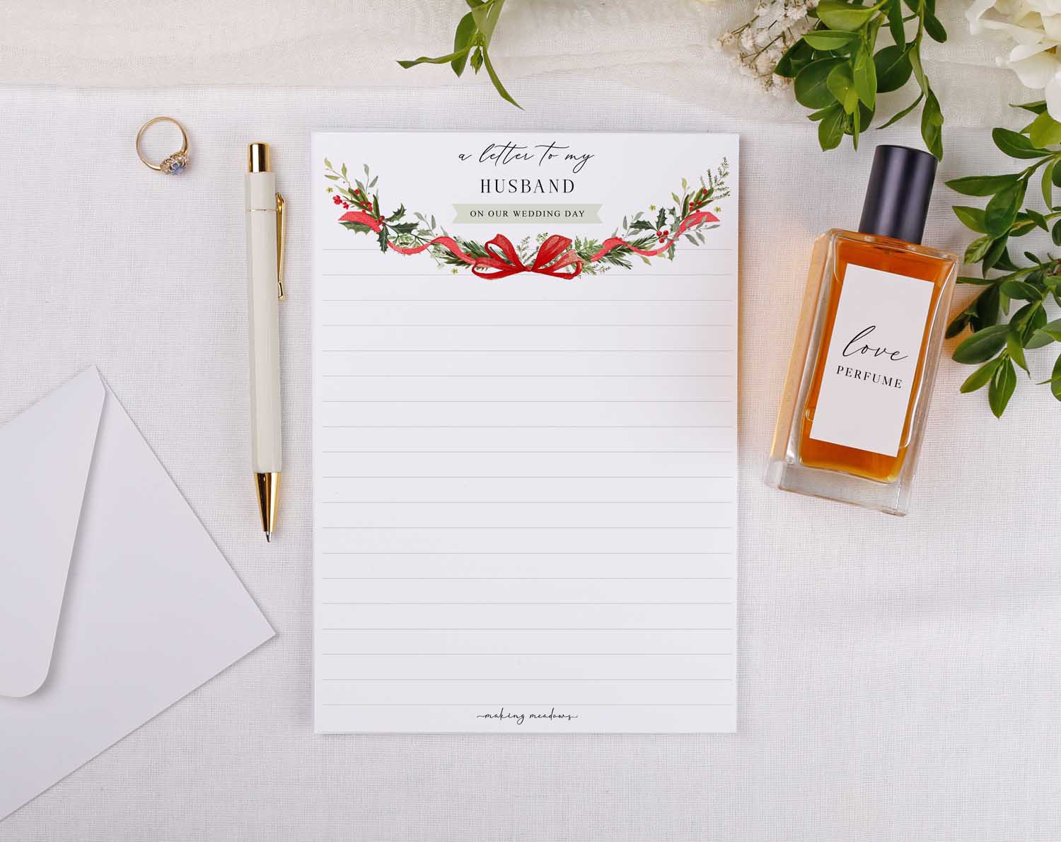 Winter Wedding Letter to My Husband with floral design, a pen, and perfume on a white fabric background.