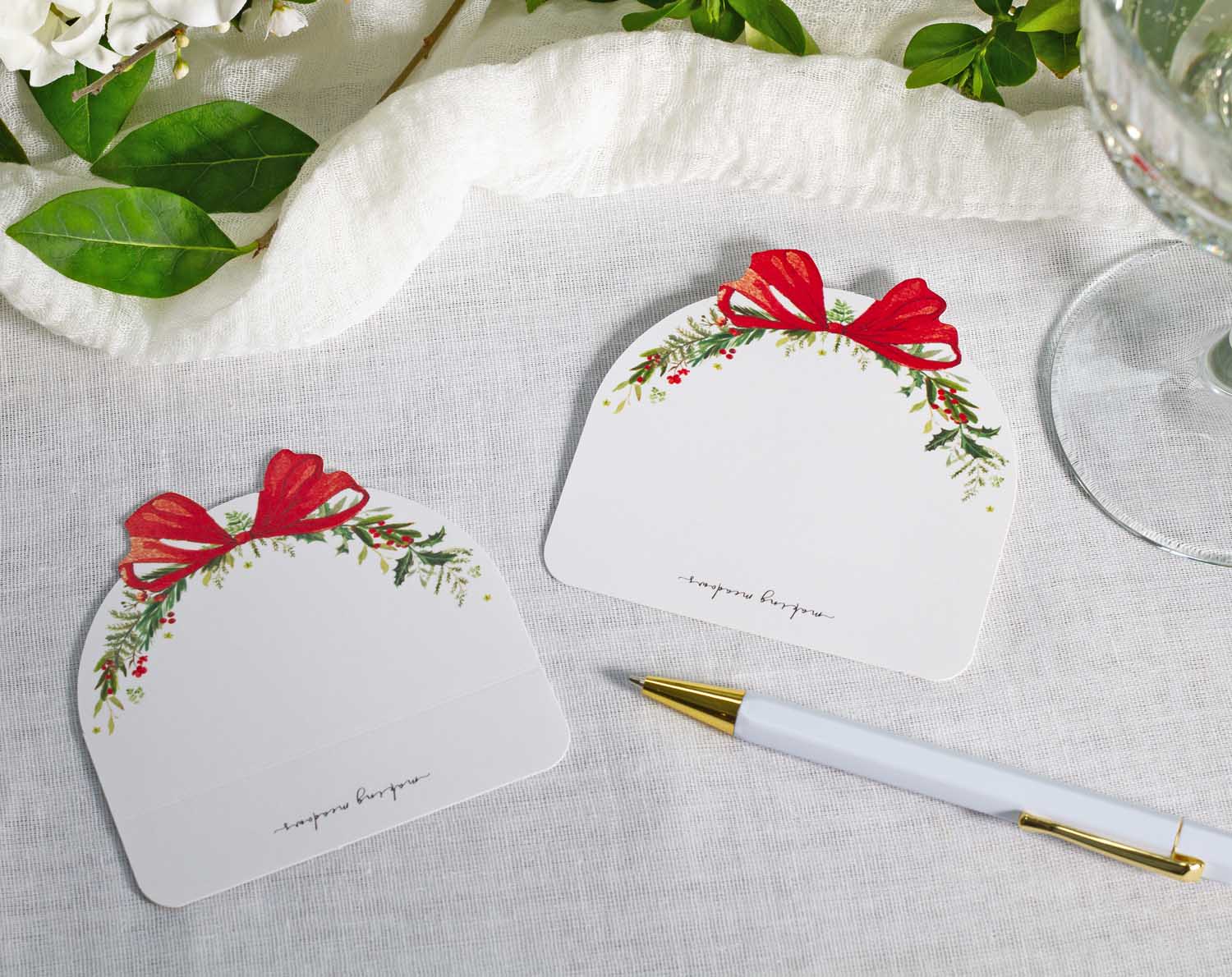 Winter Wedding Place Cards designed with festive bows and greenery, perfect for seating arrangements at weddings.