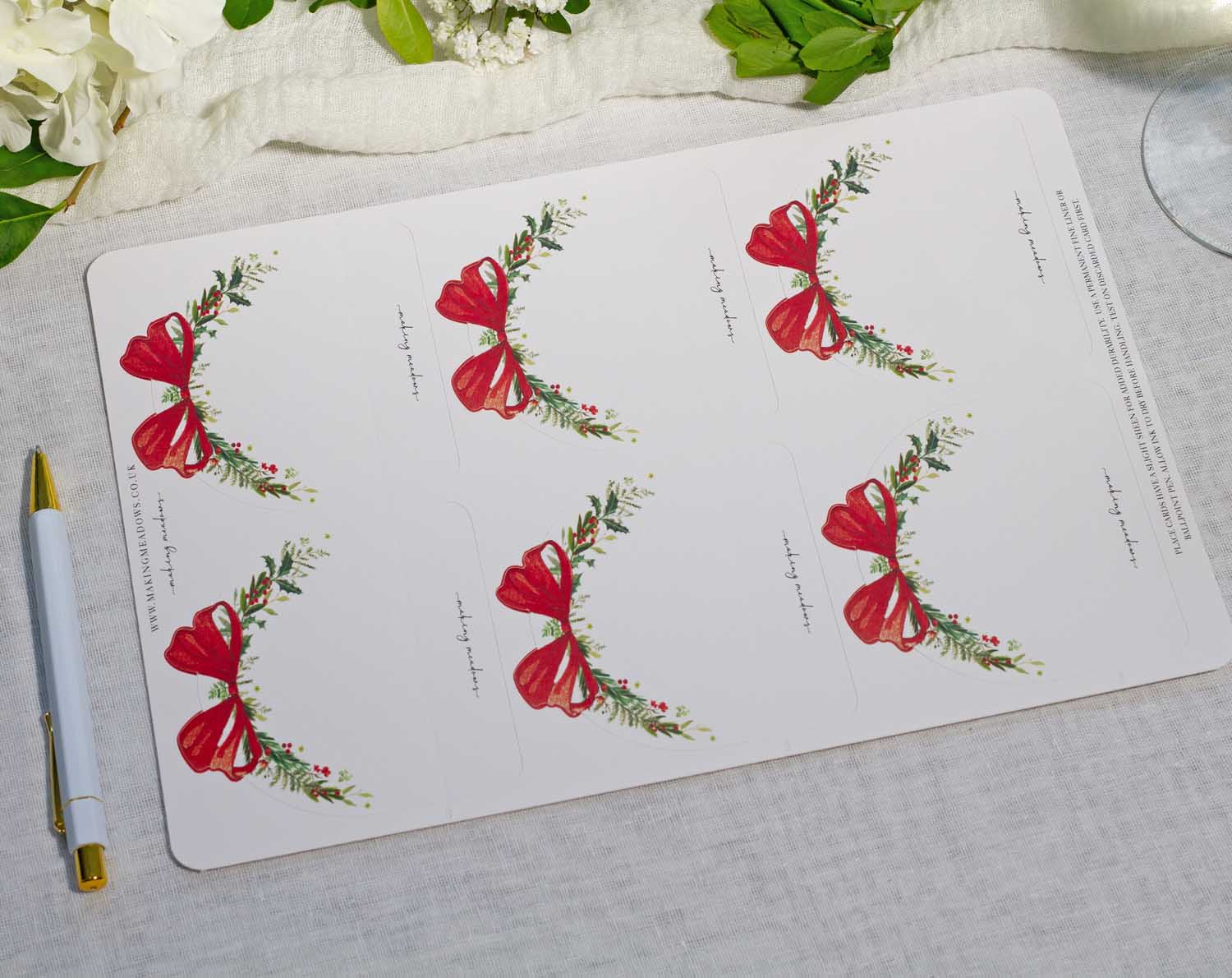 Winter Wedding Place Cards with festive red bows and greenery design for elegant table settings.