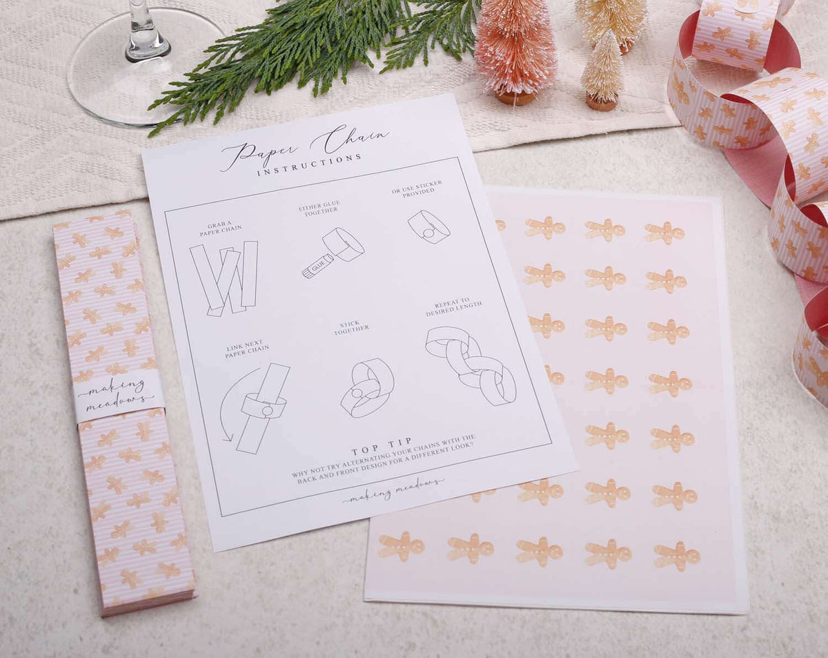 Pink Christmas Paper Chains crafting instructions and materials displayed on a festive table.