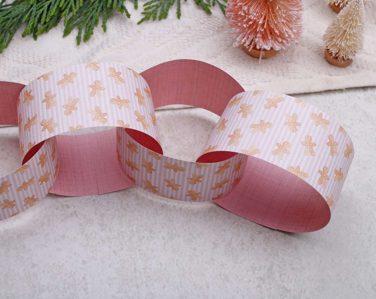 Pink Christmas Paper Chains Garland made of pink and patterned paper with gingerbread designs for festive decor.