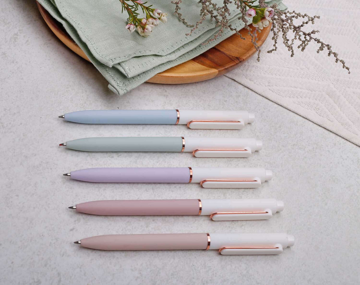 Collection of pastel gel pens with rose gold trim on a table, including apricot gel pen.