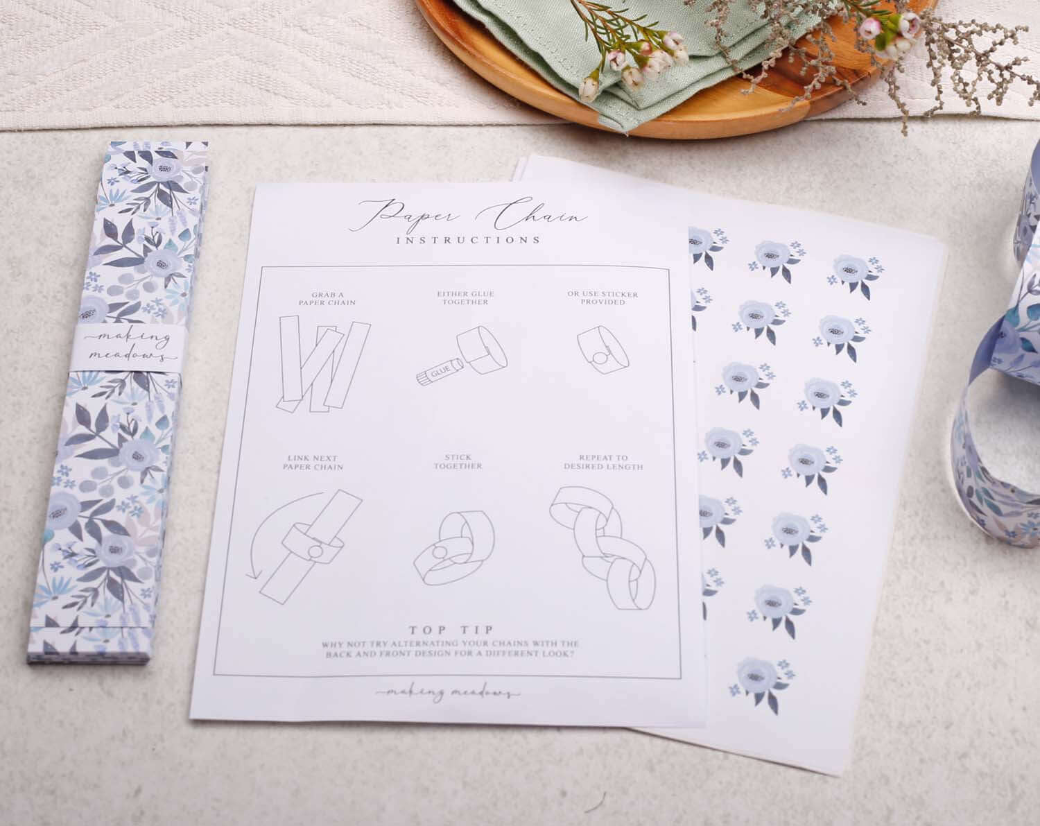 Blue Floral Paper Chains instructions and materials displayed on a table.