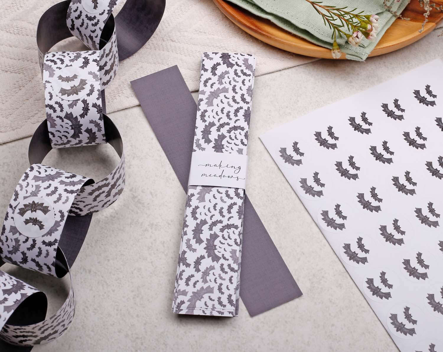 Bat Halloween Paper Chains Garland displayed with decorative papers and crafting materials.