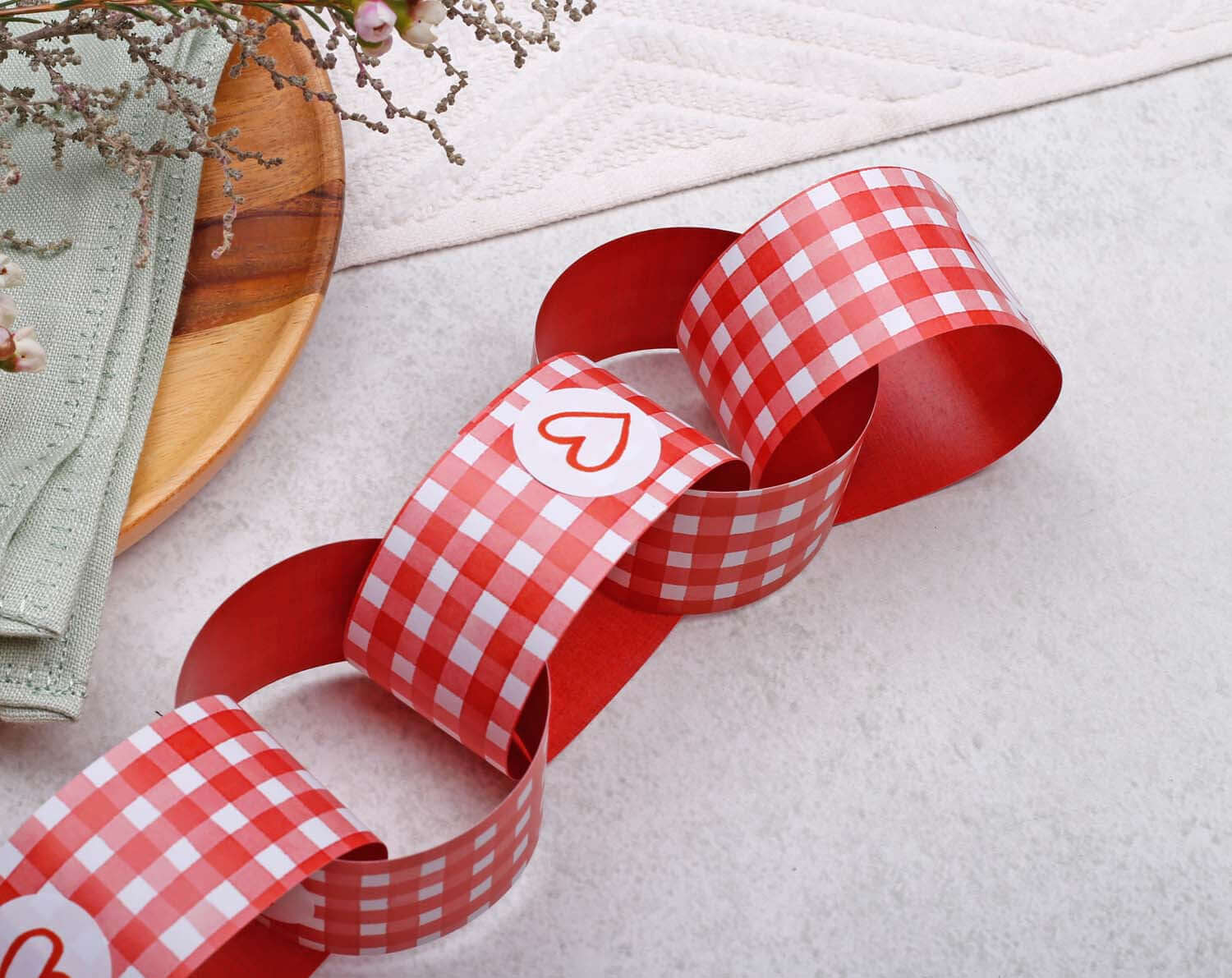 Red Gingham Paper Chains garland displayed on a light surface, perfect for decorative occasions or celebrations.
