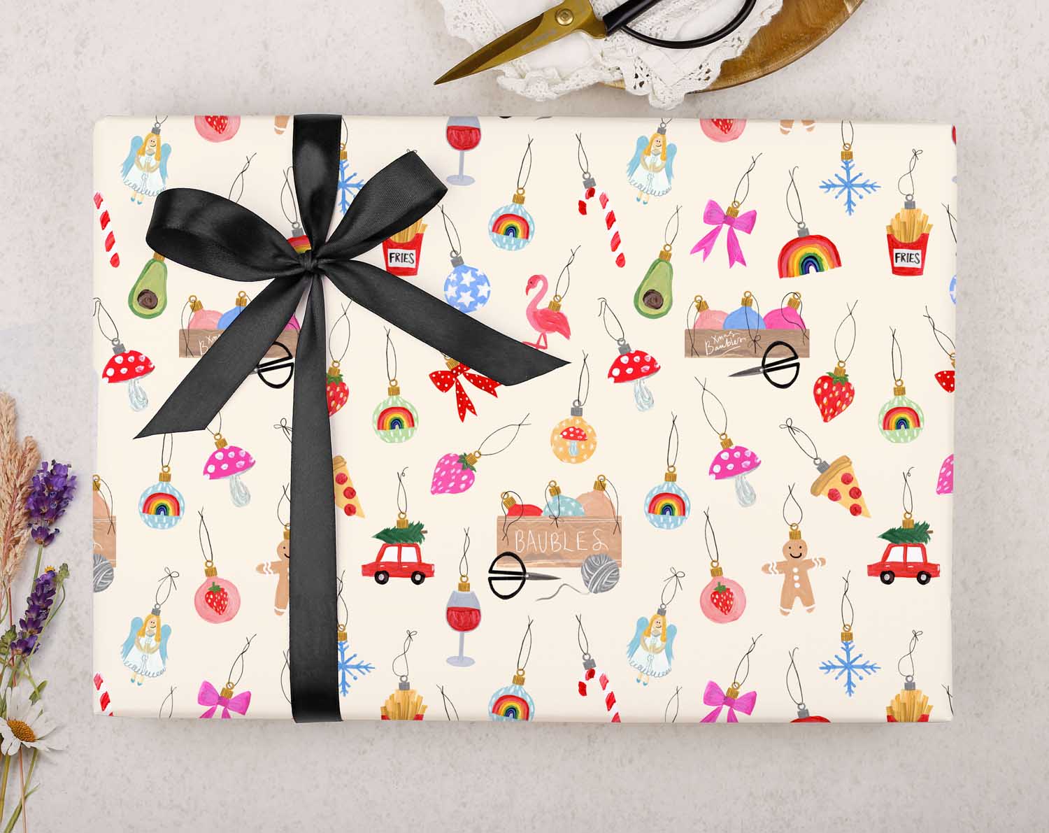 festive Christmas wrapping paper is filled with Christmas Ornaments on a cream background