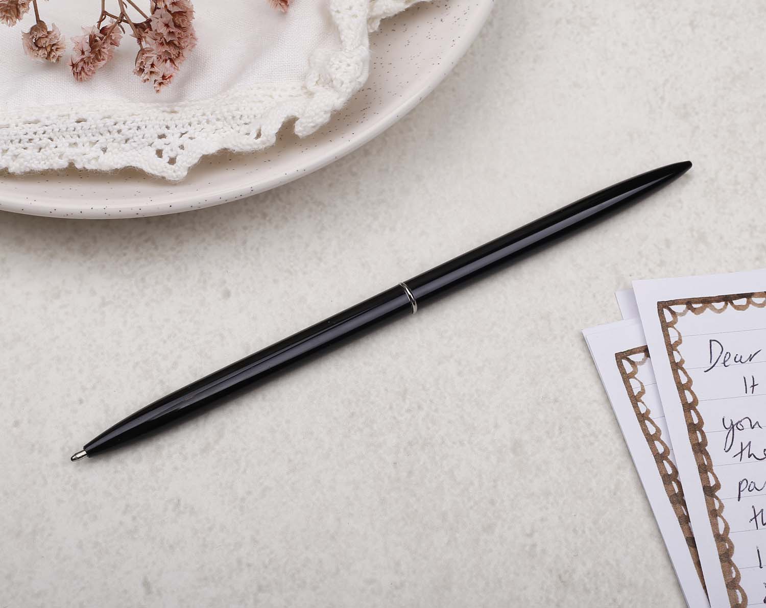 Slim black metal pen with ballpoint tip and black detail.
