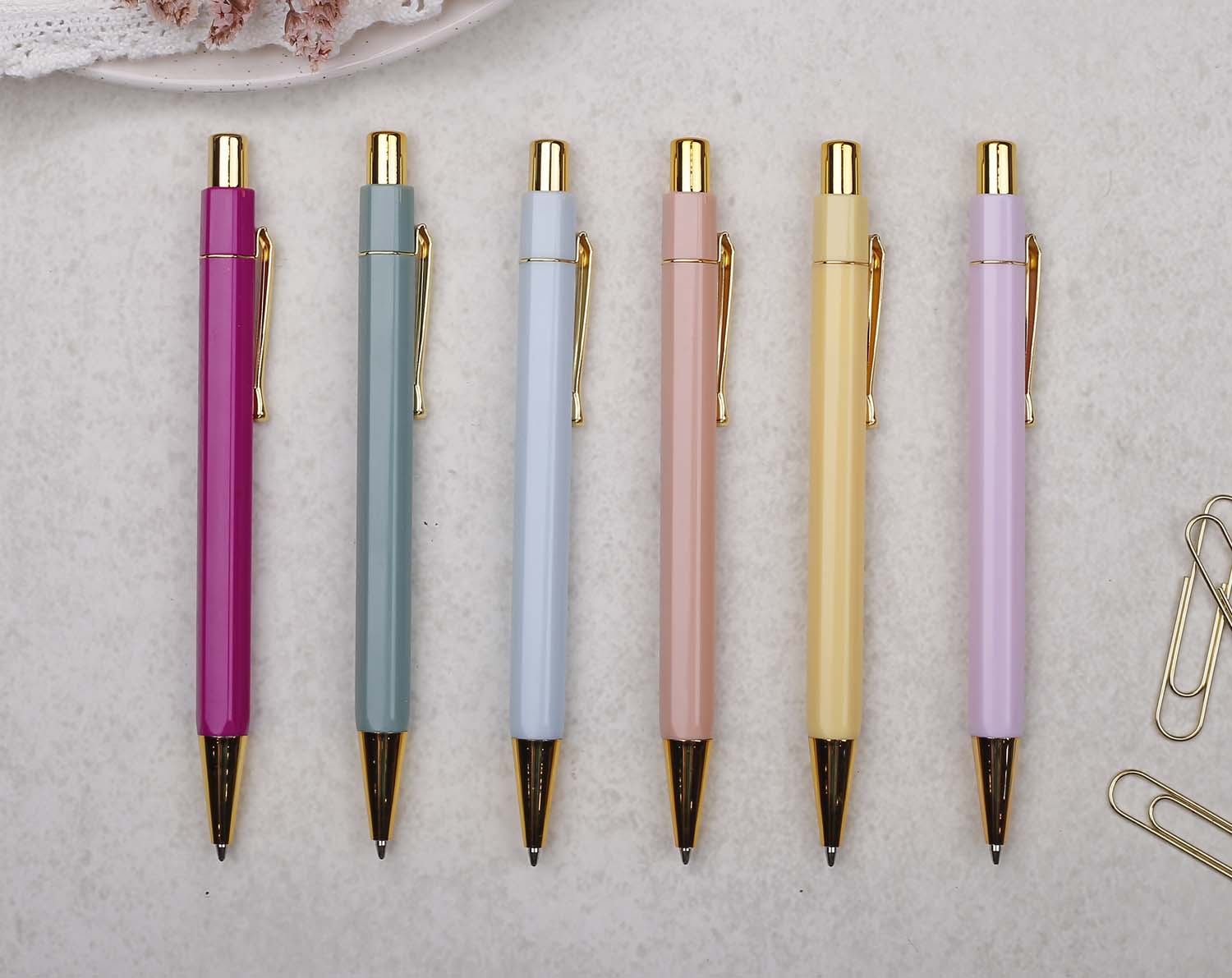 A premium sage green and gold pen with ballpoint tip and hexagonal barrel detail. 