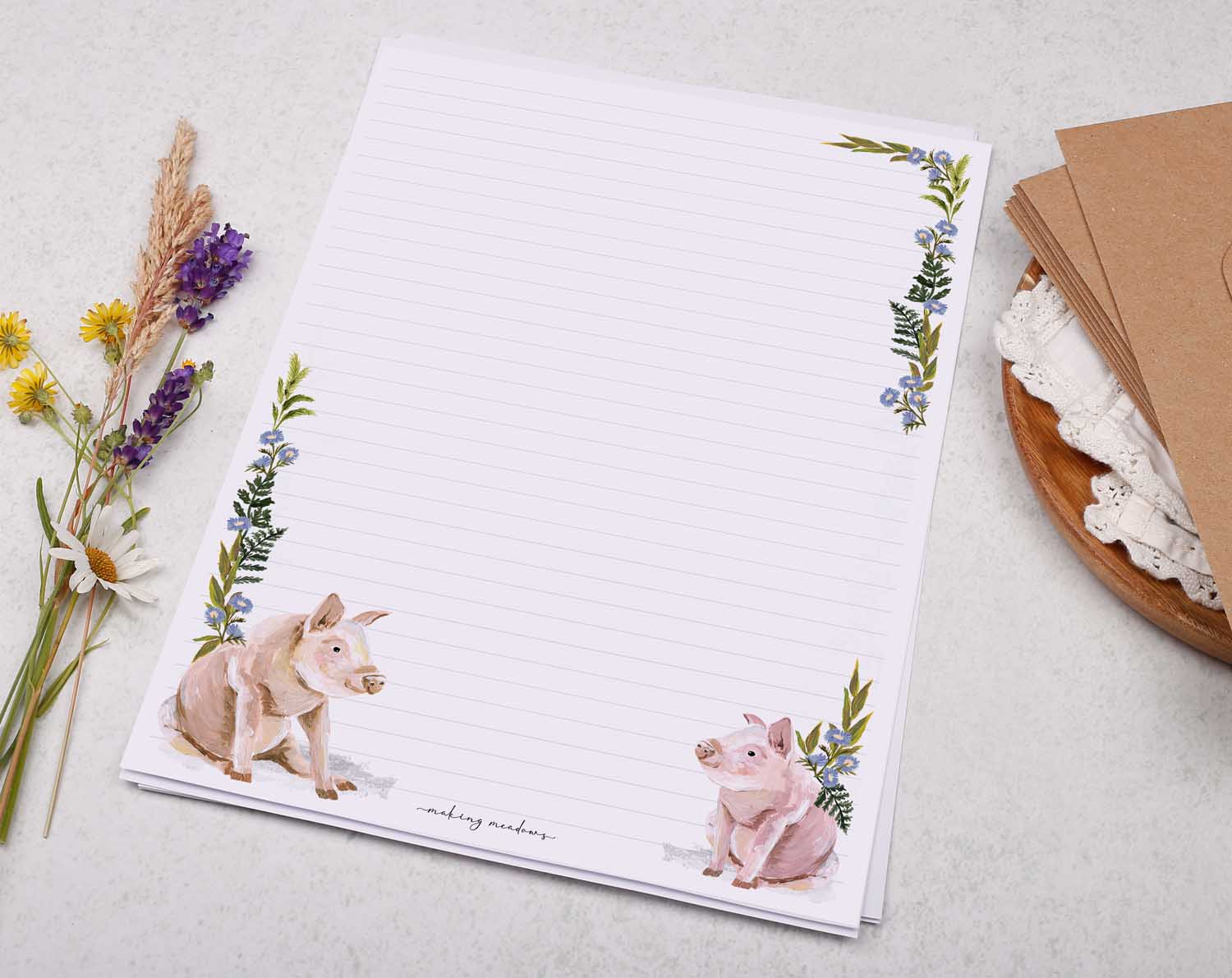 A4 letter writing paper sheets with a cute pair of farmyard pigs and a delicate blue floral watercolour border cascading around the letter paper edge.