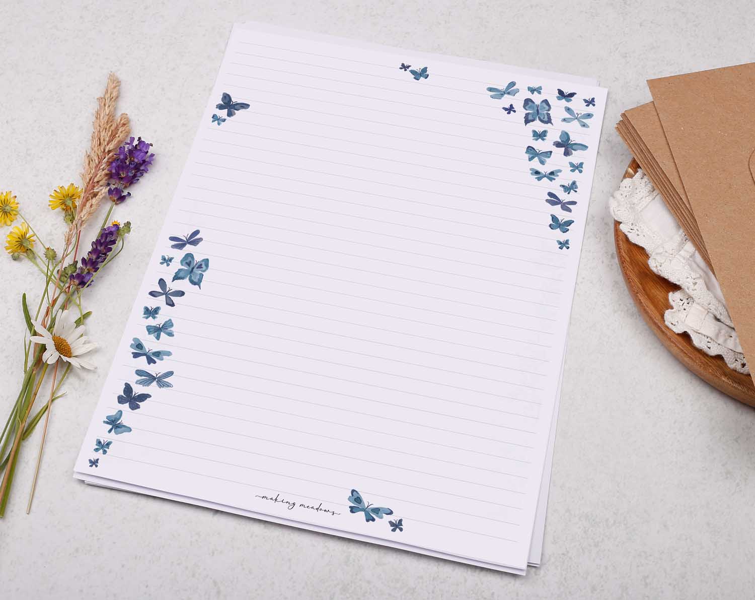 A4 letter writing paper sheets with blue cascading butterflies fluttering around the paper in a delicate pattern.