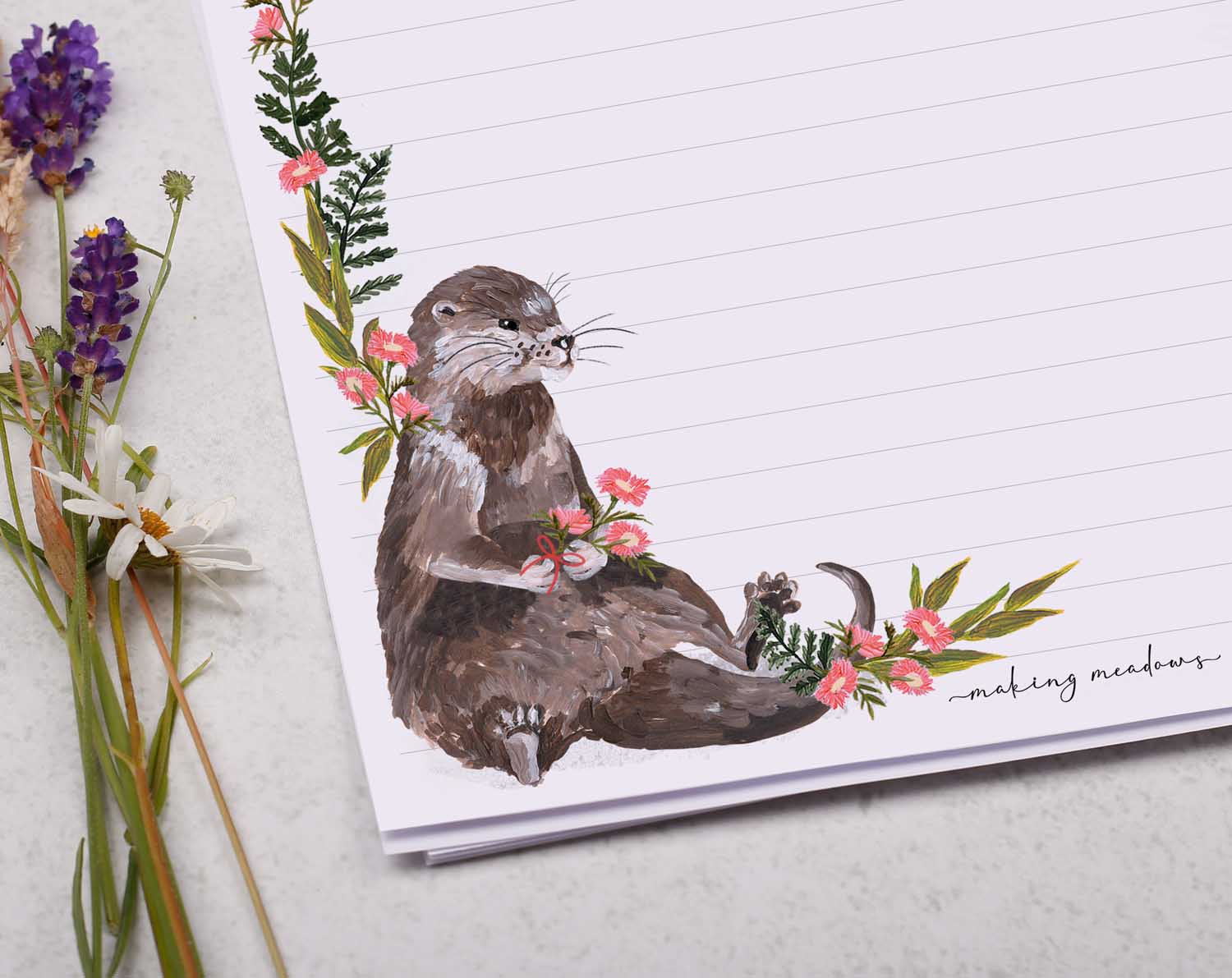 A4 letter writing paper sheets with a cute sitting otter and a delicate pink floral watercolour border cascading around the letter paper edge.