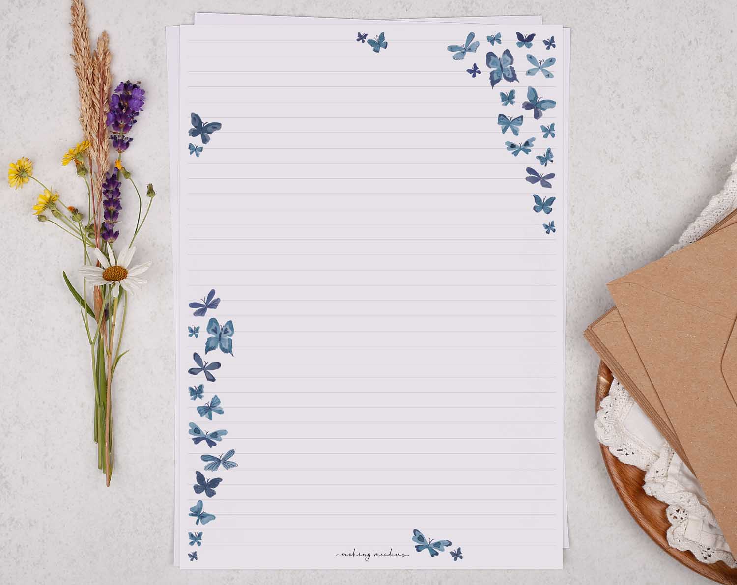 A4 letter writing paper sheets with blue cascading butterflies fluttering around the paper in a delicate pattern.