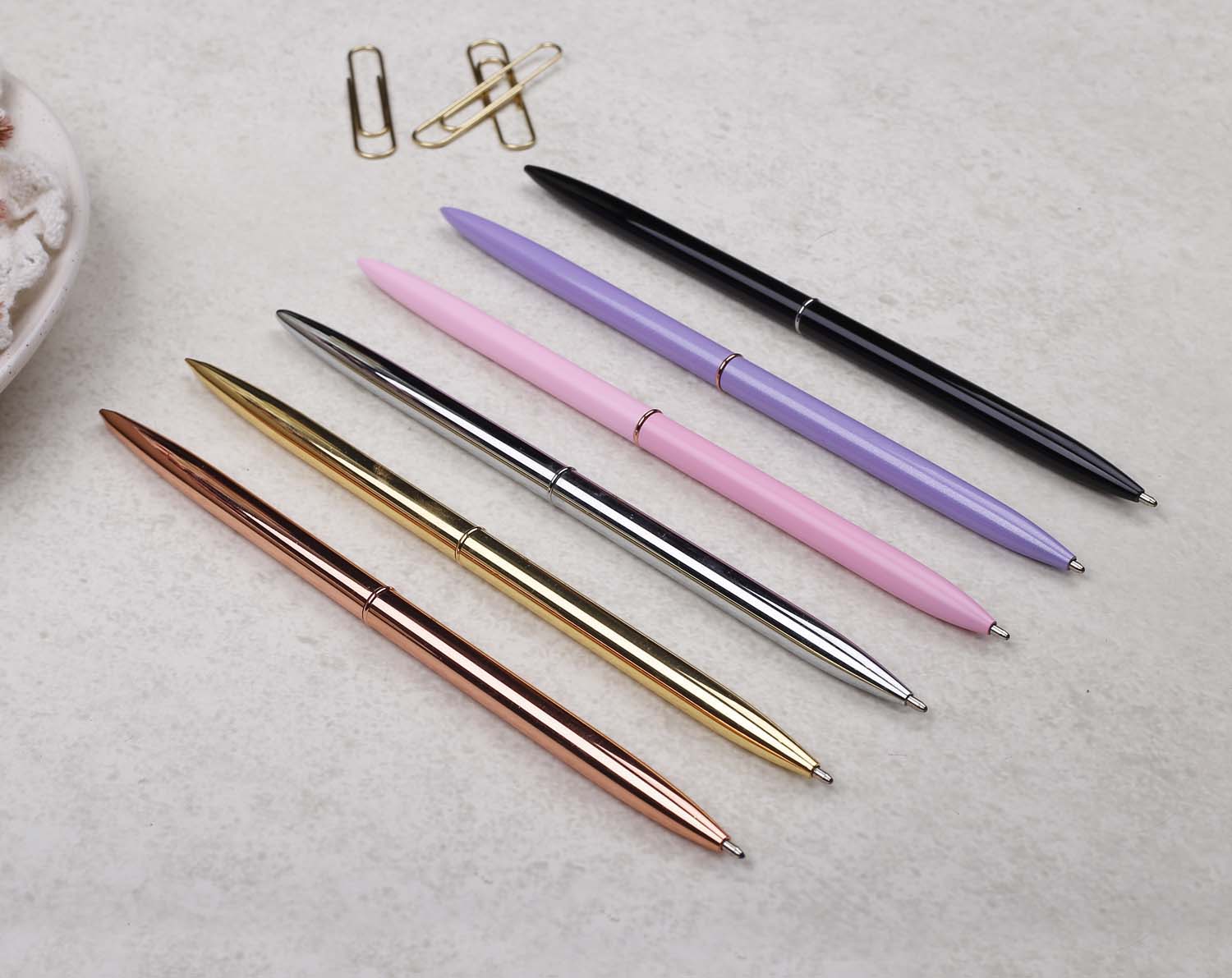 Slim lilac metal pen with ballpoint tip and rose gold detail.