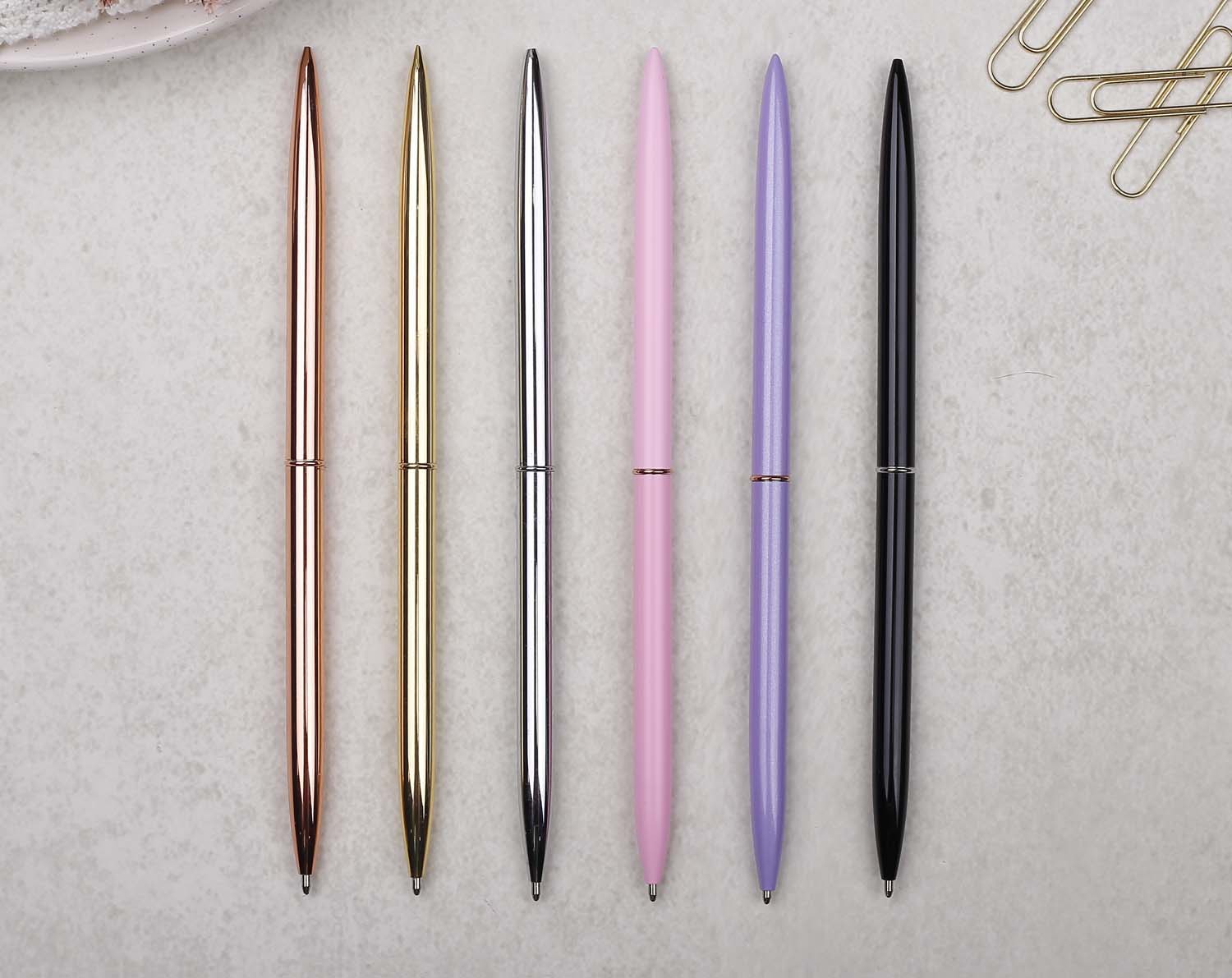 Slim rose gold metal pen with ballpoint tip and rose gold detail. 