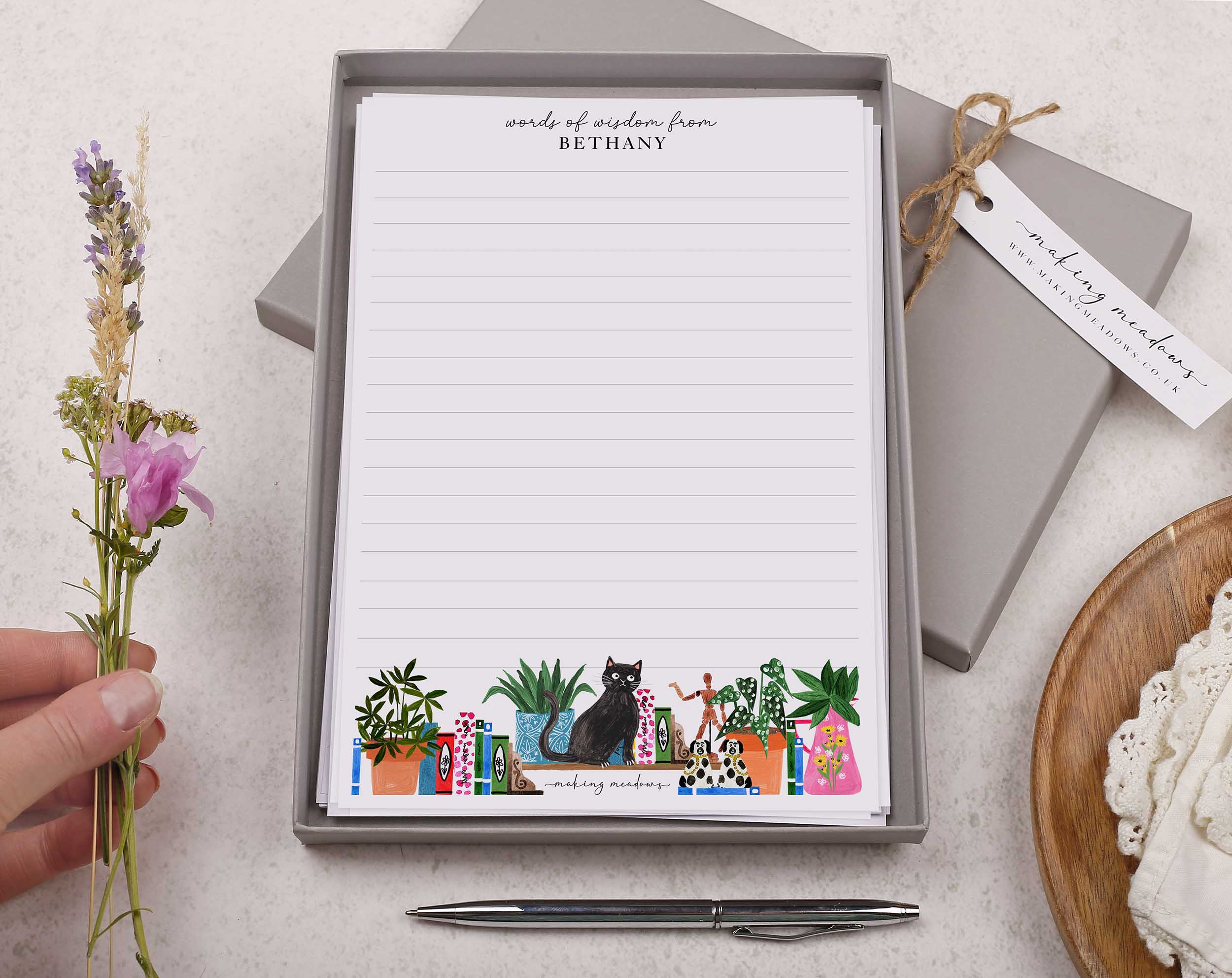 Premium personalised A5 letter writing paper set with a cheeky black cat and a bookcase bursting with books and trinkets.