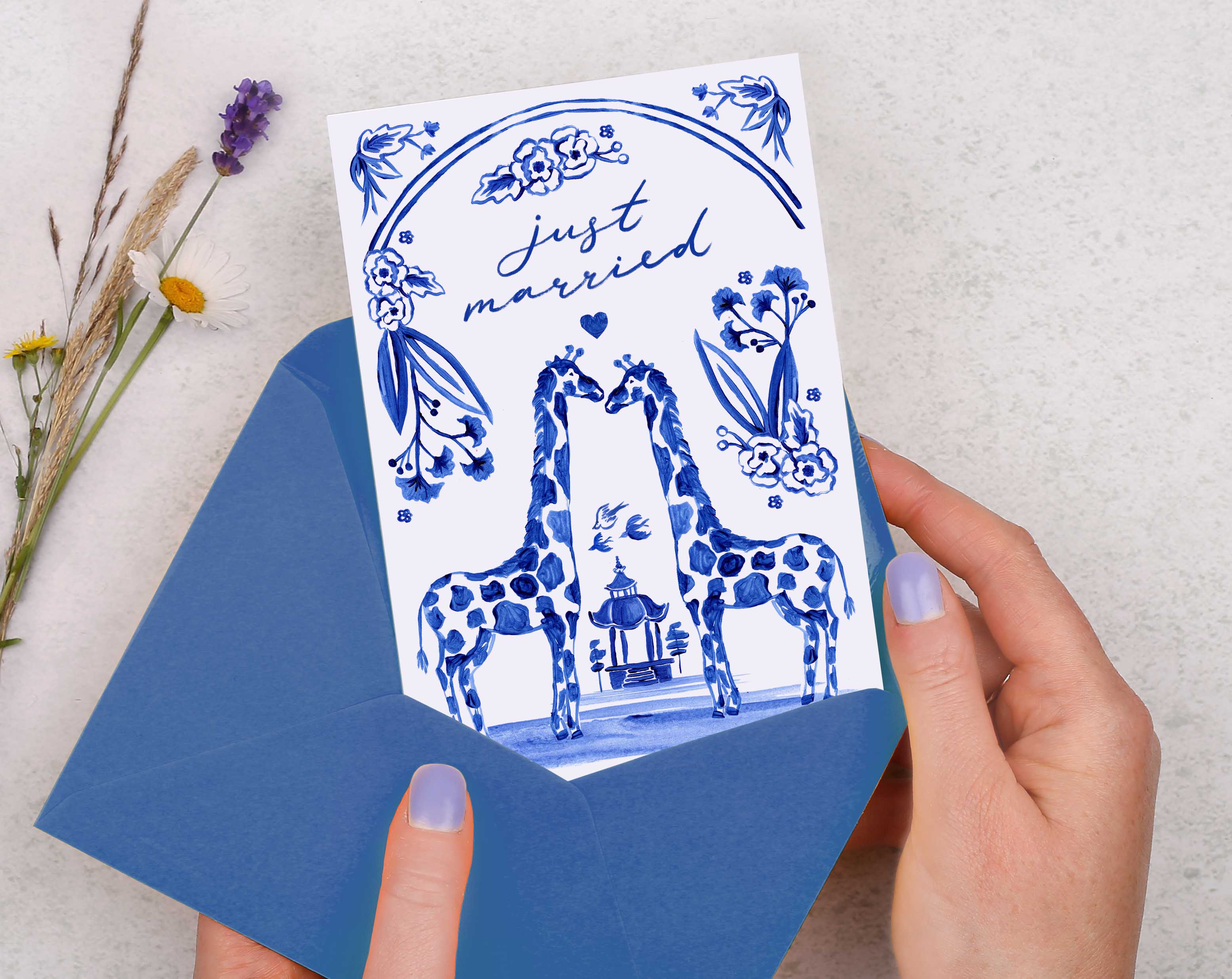 A blue porcelain inspired Just Married Card with 2 hand painted giraffes at the wedding alter.