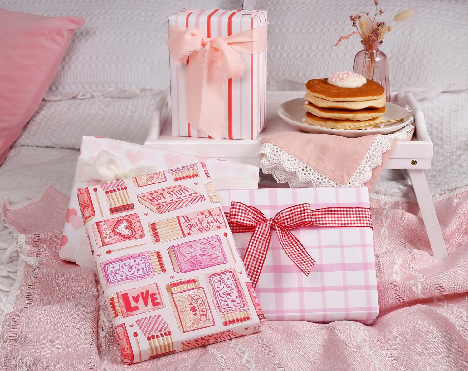 a pink and white checkered wrapping paper with a red ribbon